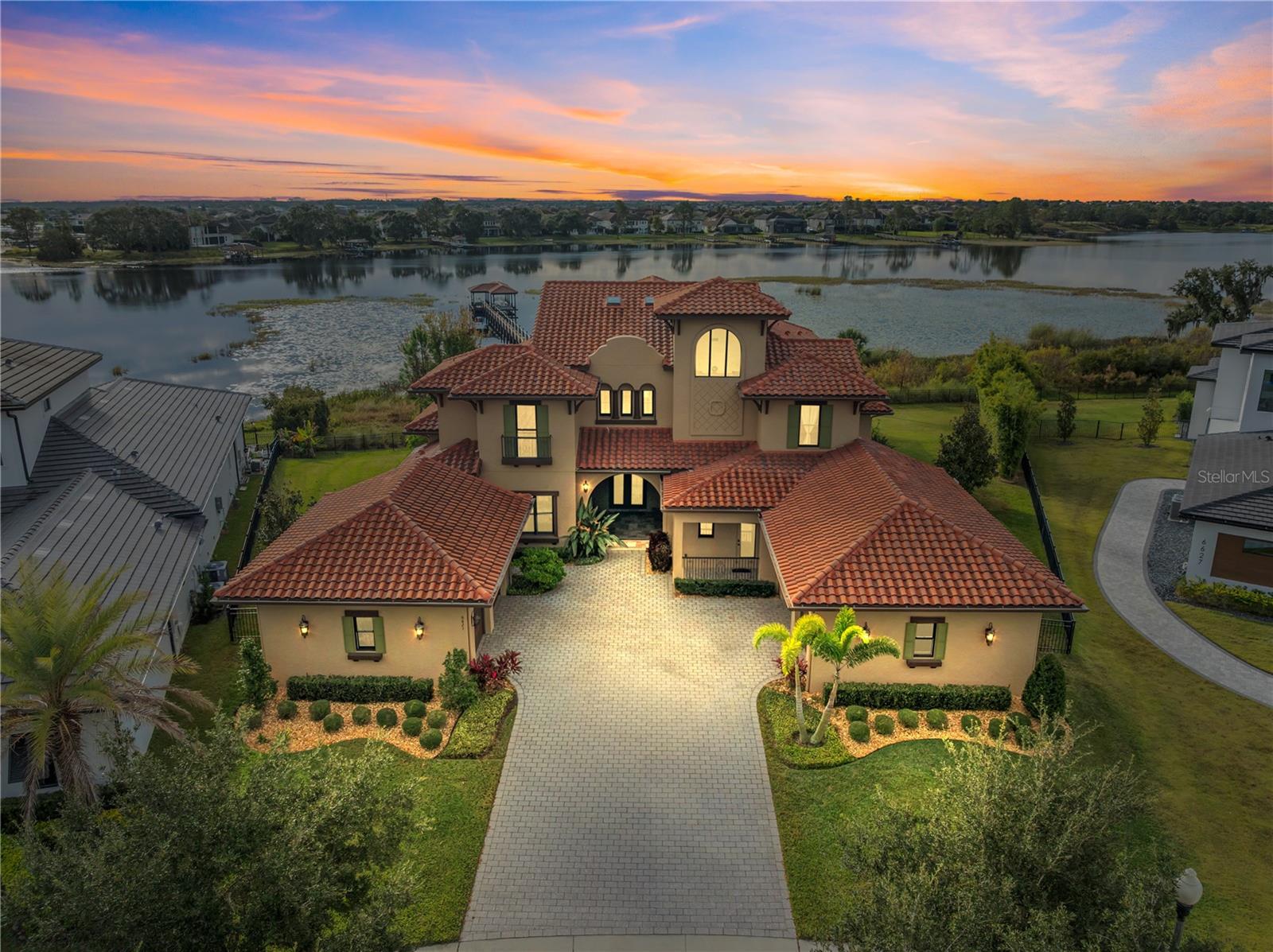 Independence * Exquisite LAKEFRONT home on Lake Hancock so close to Disney you see Disney fireworks ** Prime culdesac location and 1.39 acre pie shaped lot ** 320x4' Trex deck dock (2021) extending all the way from the patio to the covered boathouse w water, electric, powered +/-10x23' boat lift boat & powered double jetski lift (2021) ** 2019 custom home built by Sorenson Construction ** Superb quality finishes w strong attention to detail incl solid wood cabinetry kitchen & baths, laundry room all soft close, crown molding each rm, all 9' solid wood doors, custom closet built ins in all bedrooms & custom closet shelving in the addl closets, wood floors in all main rms except Atrium, custom "Old World Finish" walls & elevator ready ** 30' soaring ceilings w wood beams & Velux skylights in the elaborate Atrium w  a striking double sided precast travertine gas fireplace architectural feature that is also shared w the formal dining rm ** Charming & elegant French Provincial kitchen complete w solid wood cabinetry all soft close, farm style sink, stone counters & generous breakfast area with soothing lake views, tons of natural light and cathedral ceilings ** Expansive mahogany cooking island w natural gas cooktop and all Monogram Advantium kitchen appliances including the built-in refrigerator and built in +/-1 yr old dishwasher included  ** Incredible lake views from the family room offering a well designed tongue & groove tray ceiling with wood beams, built in custom shelving & triple sliding glass doors fully opening to the outstanding outdoor living space ** The Theatre/media room has 2 tiers for seating w floor outlets for seating, a movie screen, built in speakers & all media equipment included ** More lake views from the Game Room w triple sliding glass doors that fully open to the 3 tiered patio ** 1st floor bedroom perfect for an inlaw situation or guest suite w a PRIVATE ENTRANCE offering an ensuite bath & custom walk in closet ** Located upstairs is the primary bedrm featuring a custom designed tray ceiling and a private Juliet balcony with retractable screen & spectacular lake views ** Unbelievable ensuite primary bath featuring a luxurious round soaking tub w stunning ceiling feature above, rounded glass doors in shower displaying an outstanding tile design & custom walk in closet with built in drawers and shelving ** Library/office 2nd floor with french doors & shared wet bar between library & primary bedrm ** Unbelieavable outdoor living offers a resort style heated pool with LED lighting, a 4 seat swimout bar and spa facing the Disney fireworks ** Great ozone pool system and Pentair control ** Outdoor kitchen with grill, electric and water ** Addl features: Anderson double paned windows, 4.5 car garage w/epoxy finish & custom built in attractive storage cabinetry w/shelving system-2.5 car side, electric car charger, 2 entire home water softeners, 1 reverse osmosis in kit wet bar are included, HVAC UV light & dehumidifier +/-2 yrs, auto lights in all closets ** LOW HOA fees $194.69 incl cable & internet + incredible amenities incl 2 commun pools, play areas, a lg commun park plus other neighborhood green space & play areas thru-out neighborhood, loads of sidewalks thru-out community ** Buyer to verify square footage-All rm measuremts approx from Builders flr plan. Bookcases in den/library, TV on back patio, TV in great rm, murphy bed 1st flr bdrm, pool table, refrig in garage, wine refrig, media equipment are incl.