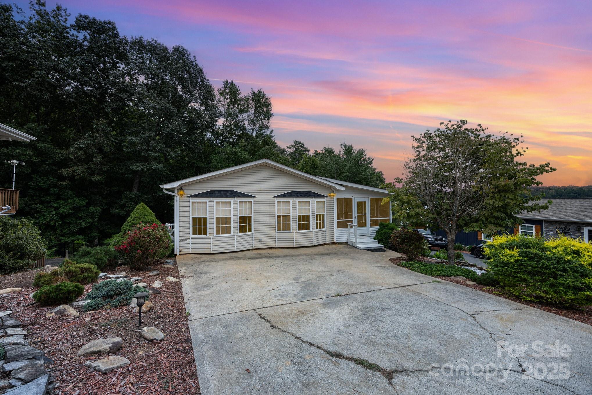 Stunning lake-view home at Badin Lake situated on a rare double lot offering extra outdoor space! Enjoy a paved driveway that leads to the back of the home with a fenced yard and a garage-perfect for parking, golf carts, or a workshop. The spacious screened porch, sprawling back deck, and gazebo create the ideal setting to relax and take in breathtaking sunsets over the water. Upstairs features a fully remodeled kitchen with newer cabinetry, solid surface countertops, stainless steel appliances, center island, and an open concept living/dining area. The updated half bath and spa-like full bath include a soaking tub, double vanity, and a custom walk-in shower. Wake up to lake views from the main-level bedroom! The lower level offers two additional sleeping areas, a large recreation/great room, and a kitchenette—perfect for guests or entertaining. Located in a gated resort community with amenities that include swimming pool, putt putt, fishing pier and more Live the lake life today!