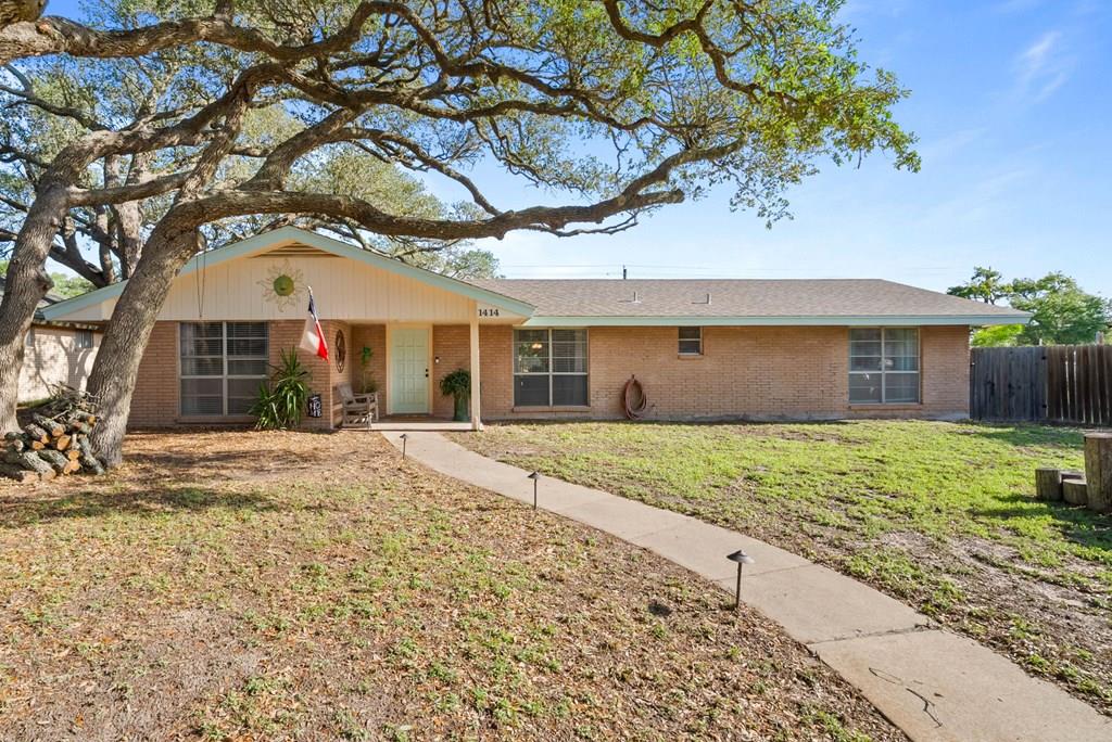 Location, space, and lifestyle — this Rockport gem delivers all three. Situated within walking distance of Memorial Park and the Hike & Bike Trail, and just minutes from restaurants, shops, and schools, 1414 Dana Drive puts everything you need right at your doorstep. With over 2,300 square feet of living space, this four-bedroom, two-bathroom home offers room for everyone. Two distinct living areas provide the flexibility to spread out, whether you need a quiet retreat or a lively gathering space. The recently updated kitchen is ready for everything from weekday meals to weekend entertaining. The oversized rumpus room is the true showstopper — anchored by a cozy fireplace and generous enough to host a movie night for a crowd. It's the kind of space that makes staying in feel like an event. Step outside to a fully fenced backyard perfect for grilling and relaxing. Covered parking in the rear off Enterprise Drive, plus additional parking along Dana Drive in front, means convenience is built right in!