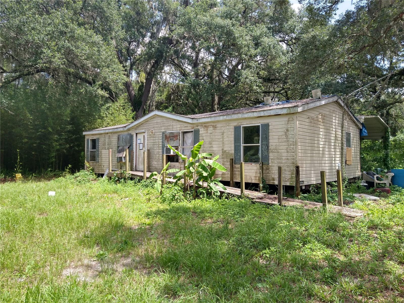 Beautiful 5-acre parcel with a 1152 SF double wide mobile home, large carport and storage building. Property also has the possibility of being subdivided.