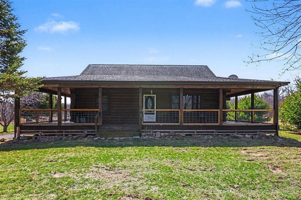 Nestled on peaceful acreage, this charming country log home offers the perfect blend of rustic character and everyday comfort. A welcoming wraparound covered porch invites you to slow down, sip your morning coffee, and soak in the surrounding nature.Inside, the home features soaring vaulted ceilings and warm wood flooring that highlight the open living space. The kitchen flows seamlessly into the living room making it ideal for gatherings and casual entertaining. With two comfortable bedrooms plus a spacious upper-level den or potential third bedroom overlooking the living room, there's flexibility for guests, a home office, or a cozy retreat.The full basement provides abundant storage with built-in shelving, keeping everything organized and out of sight. Outside, the impressive pole barn, built in 2009, is ready for hobbies or livestock and includes three horse stalls and a fenced pasture area. All of this and located in Northwest School District.