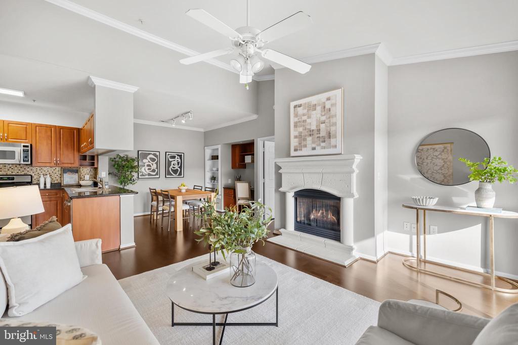 This top-floor condo filled with natural light offers vaulted ceilings and an open, airy feel that immediately stands out. Featuring two spacious bedrooms and two full baths, the layout is both functional and inviting. Hardwood floors run throughout the main living areas, and the bright living room with a cozy fireplace opens to a private balcony, perfect for morning coffee or unwinding at the end of the day. The open-concept living, dining, and kitchen space creates effortless flow for entertaining, while the office nook just off the dining area provides a dedicated work-from-home solution without sacrificing living space. The primary suite includes a large walk-in closet and a large en-suite bath. A generously sized second bedroom and full hall bath offer flexibility for guests, roommates, or additional workspace. A separate laundry room with full-size washer and dryer adds everyday convenience. Two oversized assigned parking spaces (#222/#223) are conveniently located near the building to the right of the community entrance. An additional storage space is provided. Water utilities included in condo fee. This gated community features a clubhouse, outdoor pool, and onsite fitness center creating a low-maintenance lifestyle with amenities at your doorstep. Ideally situated near Fairfax Corner, Fair Oaks Mall, Fair Lakes, and Wegmans. With quick access to Route 50, I-66, and Fairfax County Parkway commuting is simple and efficient. Schedule your showing today!