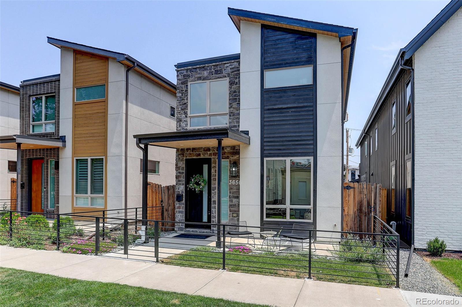 **2.25% VA Assumable Mortgage** Experience modern urban living in this exceptional MAG Builders residence ideally located in one of Denver's most desirable neighborhoods. Built in 2019 and offering over 3,300 finished square feet, this modern Highlands home combines sophisticated design, functional living spaces, and an unbeatable location just moments from LoHi, downtown Denver, Highlands Square, and some of the city's best restaurants, breweries, coffee shops, and entertainment. The light-filled main level showcases wide-plank wood flooring, a private office with striking glass walls and door, an elegant dining area, and an inviting living room anchored by a floor-to-ceiling stone-surround gas fireplace. The chef's kitchen is designed for both everyday living and entertaining, featuring quartz countertops, a large center island, luxury stainless steel appliances, tile backsplash, abundant cabinetry, and a spacious eat-in area. A convenient mudroom and powder bath complete the main floor. Upstairs, the spacious primary suite offers a true retreat with a walk-in closet and luxurious five-piece bath featuring dual vanities, a freestanding soaking tub, and an oversized tile shower. Two additional bedrooms, a full bath with dual sinks, and an upper-level laundry room provide comfort and convenience. The finished basement expands the living space with a large family room, wet bar, beverage fridge, fourth bedroom, and full bath—ideal for guests, entertaining, fitness, or media use. Enjoy Colorado's outdoor lifestyle from multiple outdoor living areas including a covered patio, rooftop deck, and private fenced yard with front and rear irrigation. A detached two-car garage provides secure parking and additional storage. With easy access to RiNo, Union Station, Coors Field, Commons Park, the South Platte River Trail, neighborhood parks, and countless local dining and shopping destinations, this home offers the perfect blend of luxury, convenience, and walkable city living.