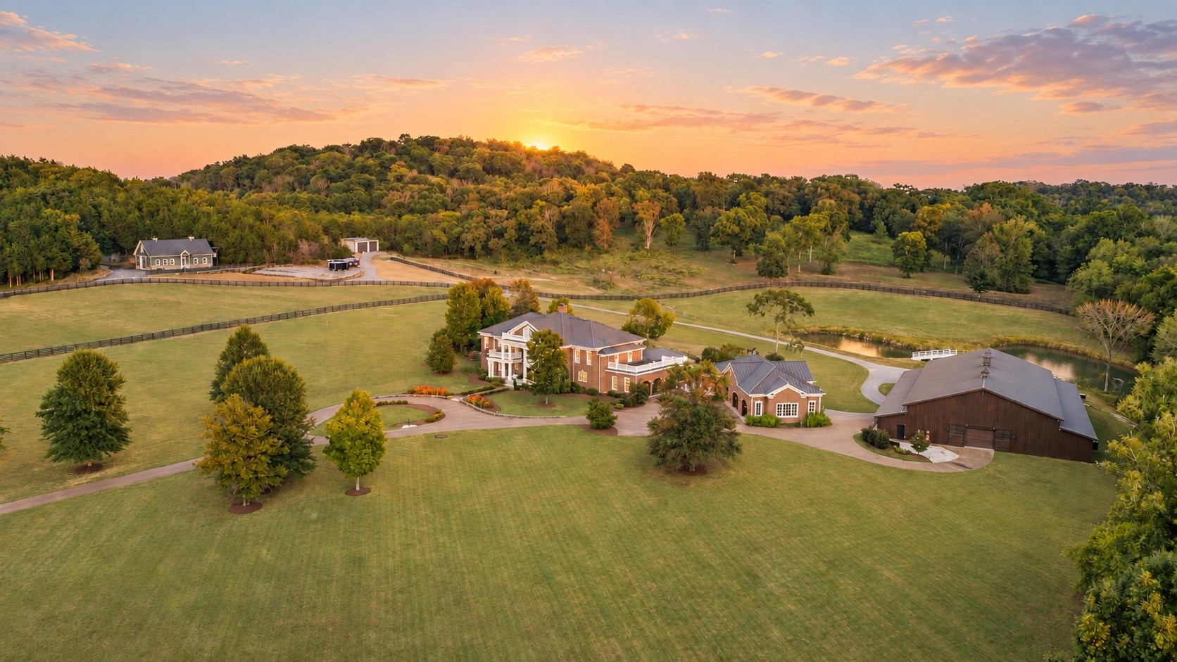 Welcome to a truly exceptional property where luxury, equestrian lifestyle, and the natural beauty of the Tennessee countryside converge. Set on over 52 picturesque acres of gently rolling pasture, mature timber, and serene privacy, this gated estate is just moments from downtown Franklin, the charm of Leiper’s Fork, and under a mile to Southall Farm & Inn. At the center of the estate stands an impressive three-level residence encompassing over 12,000 square feet including a conditioned garage. The home itself features 5 beds, 5 full baths & 2 half baths with an additional half bath in the conditioned garage, w/expansive windows, a screened rear patio, and thoughtfully designed indoor-outdoor living spaces that frame the stunning landscape. The heated saltwater pool, complete with spa, waterfall, and stone decking, provides a resort-style setting for both relaxation and entertaining.  For collectors and hobbyists, a separate climate-controlled car barn measuring 120' x 84' provides space for up to 50+ vehicles and endless possibilities. Beyond its current use, the expansive structure could be transformed into a private wellness retreat, equestrian barn, indoor riding arena, sports court, basketball or pickleball facility, or a one-of-a-kind recreational space. Equestrian amenities are equally impressive: a well-appointed horse barn with hay loft, wash rack, and 8 interior stalls including a foaling stall, an outdoor riding arena, beautiful 4 four board fenced pastures throughout the property. Additional structures include a party barn w/guest accommodations, a charming 3 bedroom farmhouse for a farm manager or guests, a large machinery shed, a scenic pond & long trails ideal for horseback riding or recreational use. Whether you seek a legacy property, a private retreat, or an equestrian haven, this exceptional offering delivers a lifestyle of sophistication, comfort & unmatched Tennessee charm. Additional SSDS approved 5 bedroom septic site.