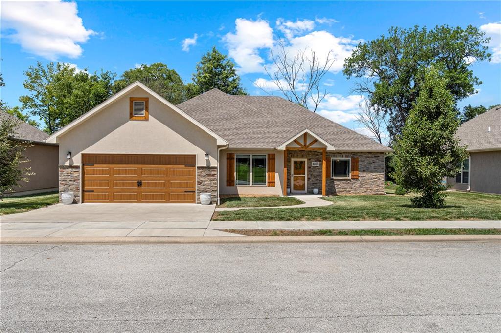 Step inside this eye-catching 2021-built home, where quality finishes and thoughtful design come together beautifully. From the moment you arrive, the curb appeal shines with cultured stone accents and clean lines that set the tone for what’s inside.

You’ll love the airy, open floor plan featuring 9' ceilings, rich luxury wood flooring, and a wall of windows that floods the space with natural light. At the heart of the home is a stunning gourmet kitchen showcasing crisp white cabinetry, a sleek subway tile backsplash, stainless steel appliances, and an oversized 12' granite island that offers plenty of prep space and seating. Elegant pendant lighting and open sightlines to the living and dining areas create the perfect space for both entertaining and everyday living.

The primary suite offers a private retreat with double vanities, a custom walk-in tiled shower, a cozy window seat with built-in storage, and a spacious walk-in closet. Two additional bedrooms and a centrally located full bath provide comfort and flexibility for guests, hobbies, or a home office.

Practical features like a dedicated pantry, large tiled laundry room with folding counter, an attached two-car garage, and a covered back patio add to the convenience. A stainless steel appliance package is included with the sale, making this home truly move-in ready.

Located in the sought-after StoneGate Subdivision in Nevada, MO, this home is part of a maintenance-provided community offering lawn care, snow removal, and trash service — giving you more time to enjoy life and less time worrying about upkeep.

Modern style, low-maintenance living, and a layout that just makes sense — schedule your private showing today!