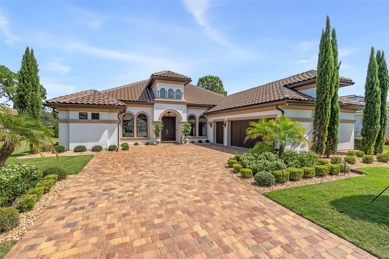 Under contract-accepting backup offers. Welcome to this exquisite estate home in Plantation Bay, perfectly positioned on the prestigious Westlake Golf Course with sweeping views and a backdrop of natural palms. Step through the double door entry and take in the elegance of crown molding, trey ceilings, Minka light fixtures, and abundant natural light that flow throughout the home. The formal dining room showcases plantation shutters, large rounded windows, tile floors, and elegant ceiling details. The oversized family room is designed for entertaining with trey ceilings, crown molding, surround sound, custom electric blinds, and disappearing sliders opening seamlessly to the lanai. Overlooking it all is a chef's kitchen featuring granite countertops, 42-inch wood cabinetry with pullouts, a travertine backsplash, a large island with charging towers, and premium GE Profile appliances including a gas range, built-in oven, microwave, warming drawer, beverage fridge, and ice maker. A walk-in pantry with custom shelving adds extra storage. The adjacent breakfast nook, currently styled as a lounge, offers serene pool views and direct lanai access. The owner's retreat is a true sanctuary with custom trim wall detailing, wood floors, tray ceiling, triple sliders to the lanai, and a spacious walk-in closet with wood shelving. The spa-inspired bath includes dual granite vanities, a jetted tub, and a walk-in tiled shower with mosaic accents. Three additional bedrooms provide comfort and flexibility, including one that overlooks the pool and has an ensuite bath. Bathroom 3 finished with quartz countertops and tile walk-in shower. Bedroom 2 and Bedroom 3 two have custom closet shelving and shared access to beautifully updated bath 2 with quartz countertops. Work in style from the private office with double glass doors, wood floors, high ceilings, and plantation shutters. The outdoor living is unmatched with an extended travertine lanai and summer kitchen featuring a gas grill, sink, and cabinetry. An oversized pool with elevated Jacuzzi, laminar water features, and a brand-new gas heater take center stage, all framed by golf course vistas and tropical landscaping. From the moment you arrive, the paver driveway, recently resealed, along with manicured flowerbeds, rock bed landscaping, and tile roof create an impressive first impression. The three-car side-entry garage includes epoxy floors, ceiling storage, and a hybrid water heater, while the oversized laundry room offers a sink, cabinetry, and extended counter space. Plantation shutters and custom blinds throughout the home add timeless style, while tile, wood, and carpet flooring have been thoughtfully placed for comfort and design. This home blends luxury, functionality, and the sought-after Plantation Bay lifestyle. Optional membership offer 45 holes of private golf, 9 tennis courts, 10 pickleball courts, fitness/spa center, dining including new 30 million dollar clubhouse, 2 pools with cabana bar & grill, full events calendar and more. Buyers of this home to receive a substantial discount on initiation fee at the club. Ask listing agent for details. Experience refined living on the Westlake Golf Course in a home that seamlessly combines timeless elegance, modern upgrades, and resort-style amenities.