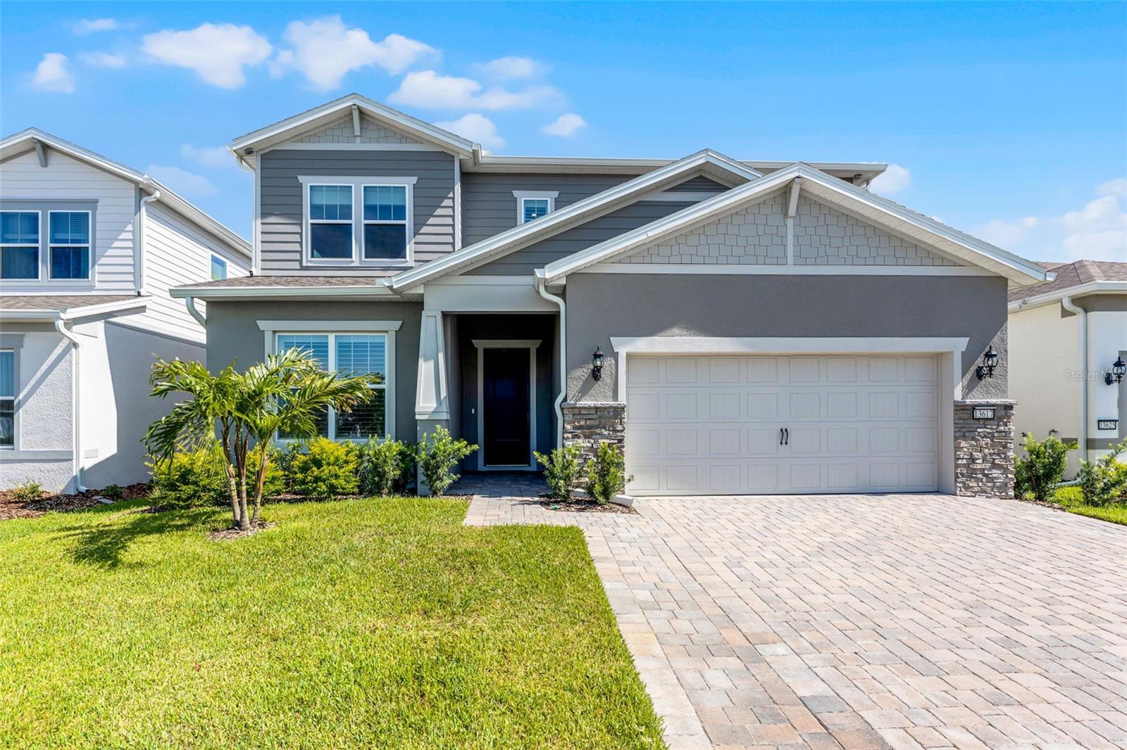 One or more photo(s) has been virtually staged. This nearly new 2024-built Yorkshire model by Pulte Homes is a showcase of refined design, modern functionality, and luxurious upgrades—perfectly positioned on a premium waterfront lot with no rear neighbors in the gated Isles of Lake Nona community. This 5-bedroom, 4.5-bathroom pool home offers thoughtfully designed spaces and elegant finishes throughout. Engineered hardwood floors span the main level, where you'll find a private ensuite bedroom, a flex room with French doors, a powder bath, under-stair storage, and an expansive open-concept layout ideal for entertaining and everyday living. The chef’s kitchen is a dream, with quartz countertops, an oversized counter height island with seating and pendant lighting, a gas cooktop, custom walk-in pantry with built-ins, and a stylish coffee station complete with a beverage refrigerator. Just off the kitchen, a light-filled dinette overlooks the sparkling pool area and pond and offers direct access through sliding glass doors. The expansive great room includes space for both dining and relaxing, with pocket sliders that seamlessly extend your living area to the lanai and screened saltwater pool and spa—both heated and surrounded by elegant travertine decking and serene pond views. Upstairs, you’ll find all four additional bedrooms, including the luxurious primary suite. A spacious bonus room offers flexibility as a media room, game room, or second living area. Two secondary bedrooms share access to a hall bath, while a third has its own private ensuite. The upstairs laundry room is well-equipped with upper cabinets, a utility sink, and a storage closet. The primary suite is a true retreat with a spa-like bath featuring a  dual sink vanity, a large walk-in shower, linen storage, a private water closet, and a custom walk-in closet with built-ins. Since moving in, the owners have thoughtfully elevated the home with a series of high-end upgrades that enhance both style and functionality. These include custom built-in closets in every bedroom, elegant plantation shutters, designer window treatments, upgraded lighting in the kitchen and dinette, overhead storage in the garage, a widened paver driveway, and a beautifully designed outdoor living space featuring a heated saltwater pool and spa. Enjoy the resort lifestyle Isles of Lake Nona is known for, with exclusive access to a gated entrance, clubhouse, fitness center, resort-style pool with cabana, splash pad, fire pit, sport courts, playgrounds, and scenic walking trails. Set in one of Orlando’s most vibrant and visionary communities, this home is just minutes from Lake Nona Medical City and the dynamic Town Center, offering access to cutting-edge healthcare, innovative schools, world-class wellness facilities, and a thriving mix of dining, shopping, and entertainment.