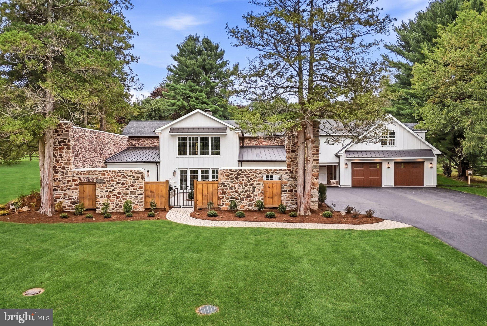 Once the coach house and stable for the historic Waynesborough Estate, this extraordinary property has been transformed into a luxurious 4 bedroom, 4 1/2 bath residence that seamlessly blends centuries-old character with modern sophistication.  Stately cedar trees flank the impressive fieldstone paddock walls as you ascend the driveway.As you step inside, you will be struck by the masterful interplay of modern amenities and enchanting historical architectural elements.  An open-concept living, dining, and kitchen area are anchored by a striking two-sided fireplace, visible from both the living and dining rooms, creating a warm and inviting flow for everyday living and entertaining alike. The dining room showcases original stone walls that speak to the home's storied past, while the chef's kitchen impresses with custom hardwood cabinetry, quartzite countertops, and premium KitchenAid appliances.A main-level primary suite offers a peaceful retreat, complete with a private patio and a spa-like primary bath featuring a soaking tub beneath a dramatic Palladian window that fills the space with natural light. The suite's closets have been custom-outfitted by California Closets, offering exceptional style and storage.French doors run the length of the first level, opening onto what was once the original horse paddock — now beautifully reimagined as a private, walled patio. Framed by the original stone walls, this serene and versatile space blurs the line between indoor and outdoor living, bringing a dramatic, character-rich backdrop to everyday life.Upstairs, two additional bedrooms and baths are joined by a spacious seating area with French doors leading to a rear patio graced by a custom pergola which provides yet another peaceful and private outdoor space to enjoy alone or with family and friends.  Above the expanded two-car garage, a versatile bonus room awaits-complete with a full bath and wet bar- ideal as a guest suite, teen hangout, home office, or au pair suite.No expense was spared in the construction of this home. Lifetime shingles were installed on the main house roof, a hot water circulation system and heated floors were added to ensure consistent comfort in the primary bath, all of the original stone was repointed, the former septic system was tied into the public sewer...these and many more upgrades and special touches come together to create a one-of-a-kind offering for those seeking history, craftsmanship, and modern luxury in perfect harmony.This home will not last... schedule your showing today!!