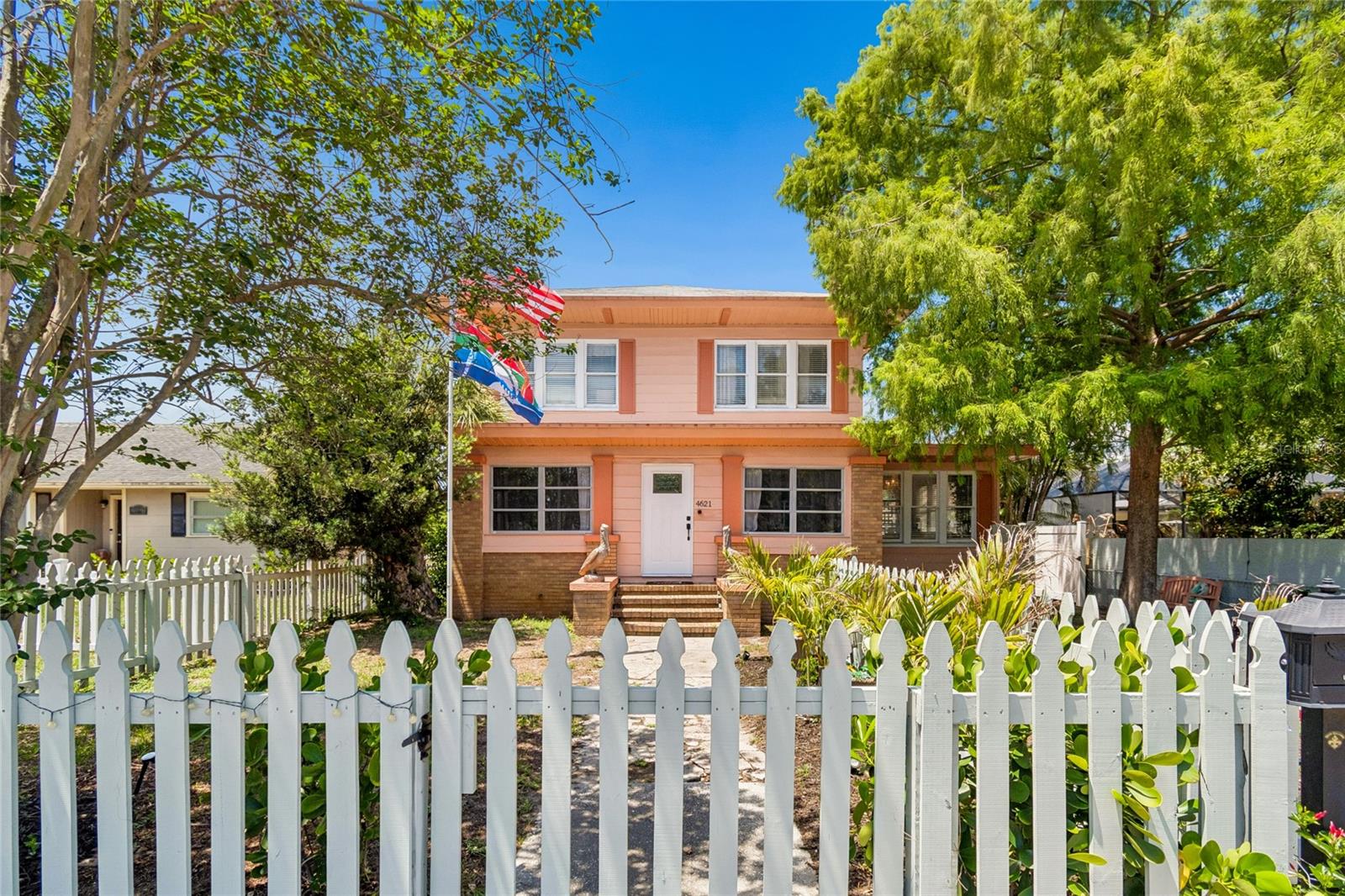 Welcome to Pelican's Perch The Pink House, a charming property in the Central Oak Park neighborhood of St Petersburg. Strategically located near Kenwood in the 33713 ZIP code, this home sits at one of the highest elevations in the city, just five minutes from downtown and five miles from the beach.This beautifully remodeled 1920s four-square home preserves its historic character with original hardwood floors, high ceilings, crown molding,, pocket doors a stunning sun room under the Cypress tree and a gas fireplace. The spacious layout includes four large bedrooms with generous closet space, two bathrooms (including a double vanity), an enclosed front porch, and a bright sunroom. A highlight of the home is the stunning dining room, featuring a designer-era mural from the 1920s and a unique chandelier from the Biltmore Arts collection.The property serves as a private oasis with a fully fenced yard and three gates. It includes a detached two-car garage with a brand-new roof, plus additional parking space suitable for a potential pool or an Accessory Dwelling Unit (ADU) for rental income.Modern upgrades include:-Smart home appliances and dual AC units controlled by NEST.- New Italian granite kitchen counter tops with updated hardware, lighting, and fans thru-out the home.-BOSCH Stainless Steel Appliances- New front and back doors equipped with smart touch coded locks.- An oversized washer and dryer.- A professional landscape package.- Firepit area for entertaining -Newly power-washed & painted with upgraded fascia and soffit replacement.Experience the best of the Florida lifestyle in this one-of-a-kind home.