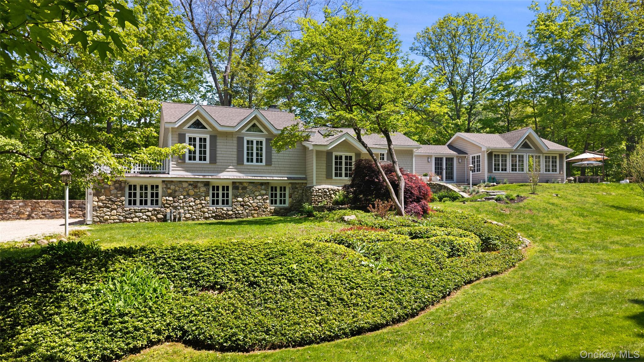 THE PERFECT COUNTRY COMPOUND. Rare offering in one of Bedford's most sought-after neighborhoods. This truly move-in ready stone and shingle expanded farmhouse blends timeless country charm with the clean lines and sleek finishes of new construction — on nearly 3 beautifully landscaped acres along a private bucolic road with direct walking access to Ward Pound Ridge Reservation. Flexible 3-bed/3-bath floorplan with attached 2-car garage and separate 2-bed/1-bath Cottage/Guest House (additional 1,281 sq ft). Discover sun-filled, beautifully proportioned spaces framed by walls of windows and vaulted high ceilings. The living room’s wide plank pine floors welcome you to a chef's kitchen and dining area. French doors open to the grounds, seamlessly connecting indoor and outdoor living, which extends to the spectacular great room showcasing bleached Swedish wood floors and expansive windows in an open-concept sitting and dining area with custom built-ins -perfect for gathering. The generous primary suite has a spa-style bathroom with heated floors, steam shower, and soaking tub. Updated office/nursery. Fully renovated lower-level complete with custom mud-room, guest bedroom with en-suite bath, and separate bedroom/office spaces. Adding remarkable versatility, the completely renovated Cottage features living/dining rooms, spacious kitchen, and laundry – ideal for guests, family or rental income. Outside, the home is surrounded by lush landscaping, stone pathways and bluestone patios – designed for easy entertaining under open skies. Private pool for relaxed summer days. Perfectly positioned within the Katonah-Lewisboro School District, at the crossroads of Bedford, Katonah, Scotts Corners, and Cross River, it offers convenient access to shops, restaurants and trains, putting Manhattan just one hour from your door. Don’t miss this opportunity to make this exceptional home yours.