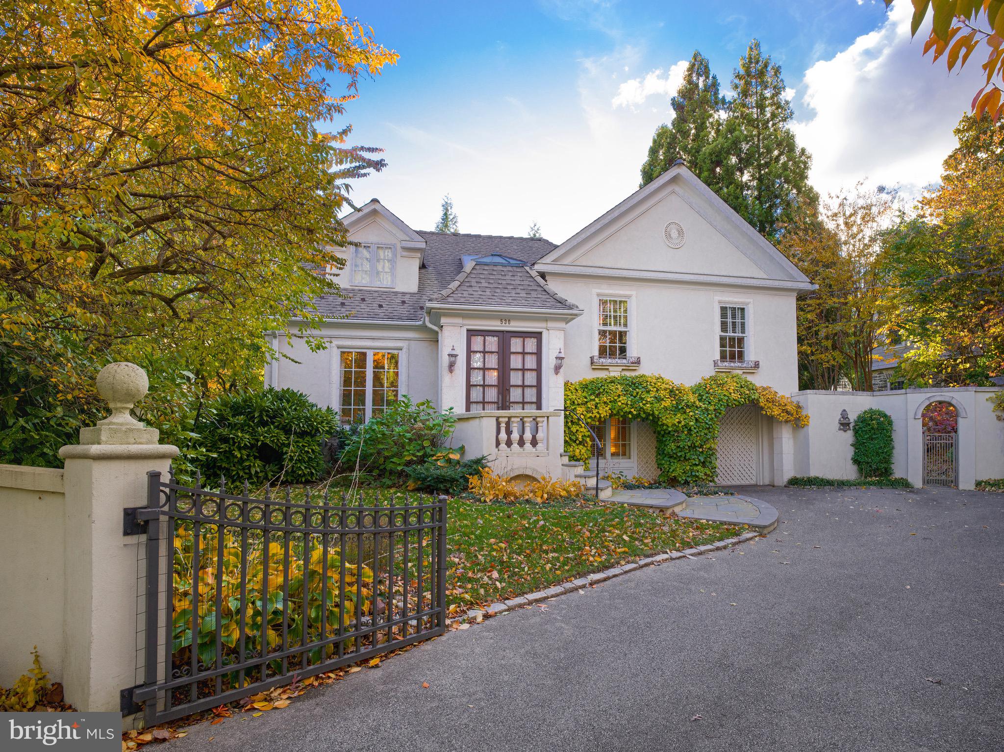 Combining timeless French-inspired architecture with thoughtful updates, this residence - comprising a total of approx 2500 sq ft - offers an elegant and stately presence on the one-way section of New Gulph Road. Beyond a walled and gated front entry lies a motor court framed by arched vines that soften the façade and a trellis-like horizontal beam supported by classic columns, adding symmetry and architectural interest. Tucked into a quiet corner of the property, a stone terrace with a fire pit provides an intimate outdoor retreat. A flagstone walkway with stone steps leads to the double-door entrance.Inside, a bright foyer opens to a fireside living room and adjoining dining area. A gourmet kitchen, appointed with stainless steel Wolf and Sub-Zero appliances, Fisher & Paykel dishwasher drawers, and a granite countertop with seating, connects to the dining room, which in turn opens to the sunroom. French doors bring in abundant natural light and open to the rear terrace.The second floor has three well-proportioned bedrooms served by a hall bath, with one currently used as a home office.Privately set on the third floor, the primary suite provides a peaceful retreat beneath a vaulted ceiling and includes a sitting area, abundant natural light, and an updated bath with a frameless glass shower, porcelain tile flooring with a marble-look finish, a quartz double vanity, and a soaking tub.The lower level includes a comfortable family room with custom built-ins that offers relaxed everyday living and connects directly to the laundry/mudroom. This well-organized area features extensive cabinetry, a utility sink, a large quartz folding counter, and inside access to the attached garage.On the lowest level, a dedicated recreation room accommodates a full-size pool table and a media area. Bright overhead lighting, built-in storage, and durable finishes make it a practical extension of the home’s living and entertaining spaces.Rear grounds provide a quiet, private setting with a flagstone terrace, paver walkways, mature landscaping, and a tidy storage shed—an inviting extension of the home for outdoor dining or relaxation. Conveniently located near the Haverford train station, Suburban Square, the Haverford and Baldwin Schools, and Merion Cricket Club, this home combines thoughtful updates with exceptional neighborhood access.