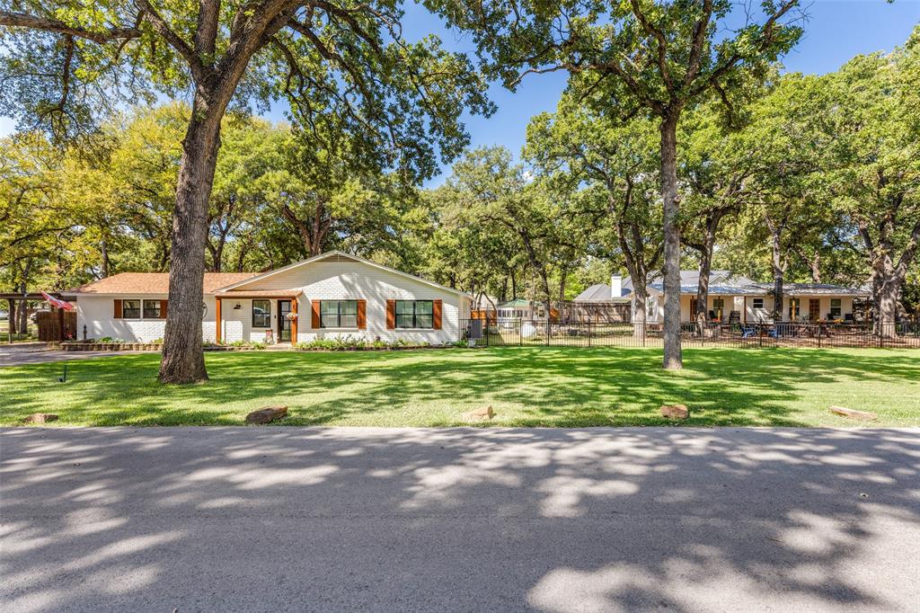 Two adjoining lots at Eagle Mountain Lake featuring a beautifully renovated main home plus two well appointed ADU's on a little over half an acre - ideal for business use, revenue investment or multi-generational living. A truly unique Eagle Mountain Lake property with endless possibilities - investment, lifestyle or both.The main residence is absolutely stunning, showcasing thoughtful interior design and quality renovations throughout. It features three bedrooms, two full bathrooms, and a half bath, an amazing kitchen with a professional-grade ZLINE propane gas stove and two spacious living areas. The main living space overlooks the treed backyard and is anchored by a striking stone, wood-burning fireplace, creating a warm and inviting atmosphere. In addition to the main home, this half acre property includes two fully finished cottages (ADU's) - each with its own private gated entrance. One cottage offers one bedroom, while the second includes two bedrooms. Both are fully furnished, and equipped with fridge and stove, and low-maintenance finishes, making them ideal for short term rentals, long term leasing, guest accommodations or extended family living.This one-of-a-kind property just minutes from Eagle Mountain Lake currently operates as a licensed B&B. No HOA. No city taxes. Tucked away on a quiet cul-de-sac with mature trees, this tranquil setting offers privacy, versatility and exceptional opportunity.Extensive renovations were completed between 2020-2021, including: *New Roof in 2019, *Updated electrical and interior plumbing in 2021, *Updated windows (excluding primary bedroom) in 2021, *New Septic system servicing main house and cottages in 2021, *Flooring, shiplap accents and full bath renovations, *Regrading of both lots for flood mitigation and improved water flow to the lake, * and much more.This property consists of two separate lots with two tax ID's and must be sold together, offering a rare and flexible ownership opportunity.