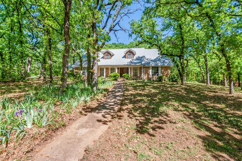 Enjoy the feeling of living in the country with the large lots, no HOA and abundance of trees and the small town feel of the City of Colleyville with easy access to the large city life of Dallas or Fort Worth.  This 1970's vintage home built by the original owners is now in an estate and is calling for new owners to bring their own vision to this beautiful piece of land. The home is in significant disrepair; therefore, list pricing is for the land itself.  If buyer wishes to purchase home as is the list price is $850,000. Features of the home include combination formal living and dining rooms, paneled family room with a wall of bookshelves and cabinetry and a large brick fire place with raised hearth, an island kitchen with nice sized pantry, double ovens, island with electric cooktop where meals for friends and family were prepared with love and then gathered around the table in the formal dining room while the kids had their special table in the breakfast nook. Nice sized utility room with half bath and secondary pantry.  Master bedroom on east side of the first level along with another bedroom and bath.  Upstairs are three more bedrooms and one bath, one of which would make a great living area or game room for the kids.  Three areas of walk-in attics and plenty of storage with walk-in closets and niches with cabinetry under dormer windows.  Second bedroom upstairs has balcony with French doors overlooking back yard. Roof replaced a few years ago.
Two car garage is detached, plus a water well is on the property that initially was set up as a sprinkler system.  Invision the potential for your family in creating your own dream home on this land.