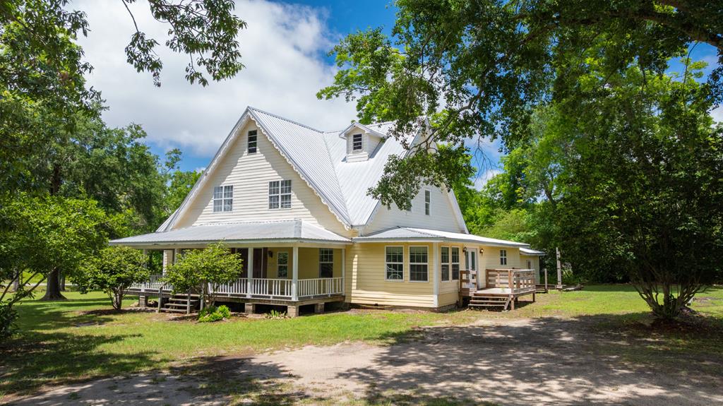 Built in 1900 or possibly earlier, this 5 bedroom, 4 bathroom home is full of character, space, and opportunity for the buyer with vision to bring it back to life. With over 5,000 square feet, the home offers the kind of scale and flexibility that is increasingly hard to find.  Inside, you'll find original hardwood floors downstairs, three decorative fireplaces, updated windows, a large kitchen, and several updated bathrooms already in place. The massive first-floor primary suite creates a practical layout for multi-generational living, offering the option for older family members to stay downstairs while younger family members have space upstairs. One of the upstairs bedrooms even features its own attached full bath, creating the potential for a second primary suite.  The living room includes a separate nook that could serve well as a home office, reading area, or playroom. Outside, the covered front porch offers a welcoming spot to relax, while the metal roof adds long-term durability.  Situated on a 0.71 acre corner lot within walking distance of shops and restaurants in downtown Ochlocknee, this property combines small-town convenience with the charm and presence of a historic home.  This home will require some elbow grease, but for the right buyer, it presents a rare opportunity to create something truly special.