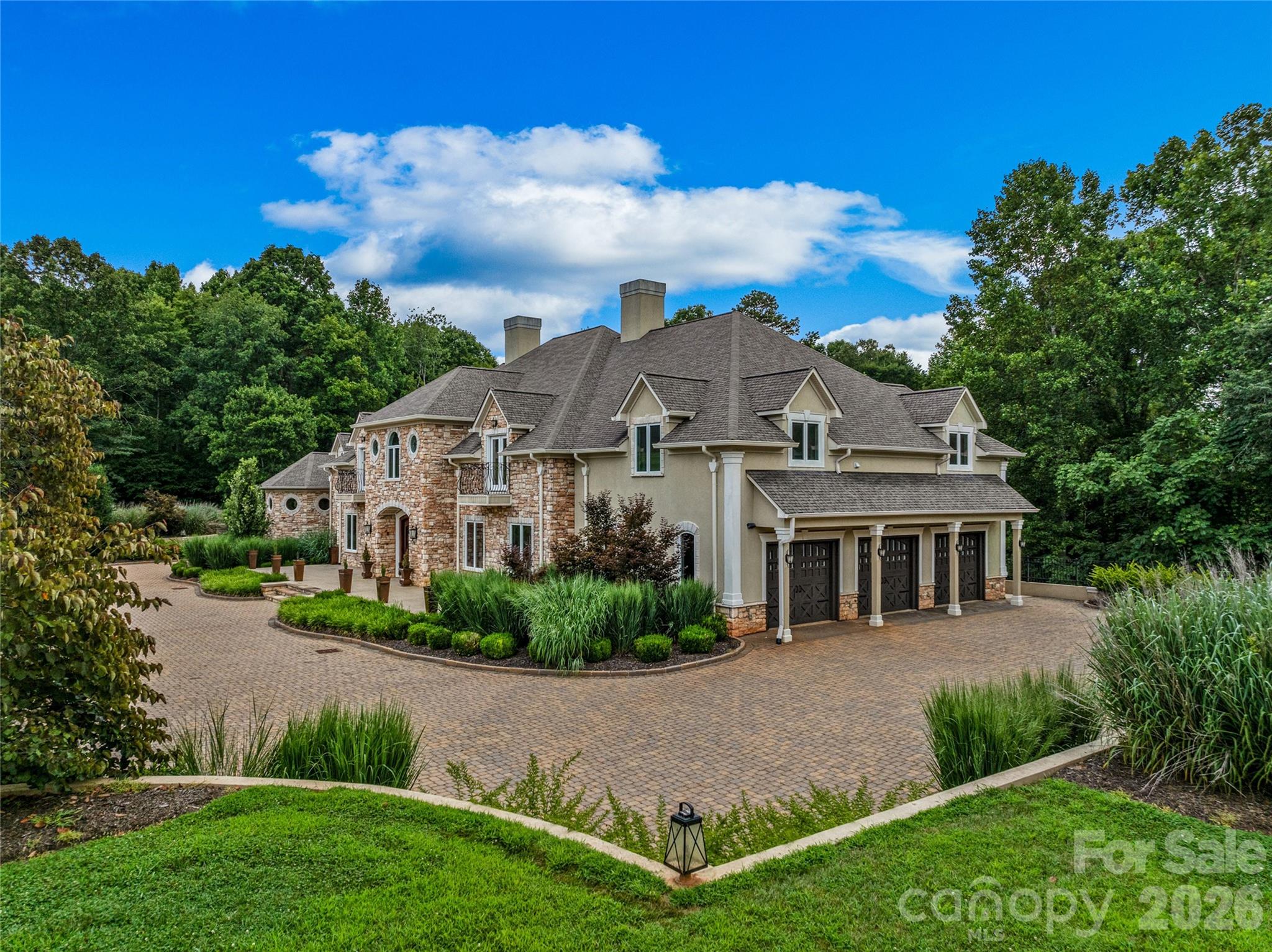 Experience unparalleled luxury, quality craftsmanship, and abundant spaces at this one-of-a-kind property! A stunning brick paver driveway framed by meticulous landscaping welcomes you home. The main level is perfect for entertaining, showcasing a great room with custom library, family room, dining area, and chef’s kitchen with plentiful storage. Ascend via the grand curved staircase or elevator to the upper level, home to the primary suite and additional bedrooms. The primary suite features a private covered balcony, while the opulent bath boasts a steam shower, soaking tub, walk-in closet, wet bar and laundry area. The lower level offers additional finished spaces, including a kitchen, living area, bonus rooms, and full bath. The +-27 acre property offers complete privacy, open spaces, and potential areas to create pastures. All considered, this home offers an exceptional value that is rarely found, perfectly blending top tier construction quality and charm with a spacious floorplan.