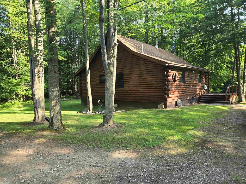 Words cannot describe the beauty of this quaint log cabin home in the woods!  This property has so many picturesque views, it is truly amazing. Located about a half mile from Lake Huron, it is close to public parks and is between Port Austin and Port Hope. The cabin has had numerous updates, including update flooring and Windows.  The kitchen has been redone and reflects the decor of the home.  Woodstove in living room can heat whole house if you want.  Endless supply of wood to cut.  There is a first floor bedroom and 2 up.  1/2 bth upstairs.  The home comes with all the furniture.  The deck and the porch have been freshly stained.  Amazing sitelines from both the porch and deck.  There is a large detached garage that has a cement pad behind it that could serve multiple uses.  There are trails meandering throughout the wooded parcel for amazing views.  Wildlife abound....many large deer taken of this property.  Located on a paved road about 30 minutes from Caseville.  If you are looking for seclusion and wooded serenity, go no further!  NOTE: Audio Visual equipment in use.  Seller is monitoring property.  Must have licensed agent accompany prospective buyers.  Seller will contact authorities if there are unauthorized people accessing property.