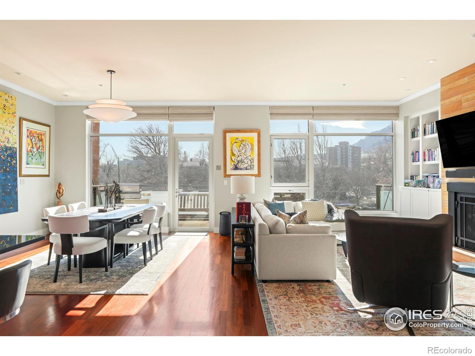 Bathed in southern light with iconic Flatiron views, this downtown Boulder residence delivers refined living just moments from Pearl Street. Set within a secure, high-end building, this spacious single-level condo balances a timeless, comfortably modern aesthetic with exquisite craftsmanship throughout. The open-concept living and dining area is anchored by a gas fireplace with a floor-to-ceiling Fieldstone surround and framed by a wall of windows that capture dramatic mountain views. Brazilian cherry floors, 10-foot ceilings, custom built-ins and a dedicated work alcove elevate both form and function. The updated chef's kitchen features custom wood cabinetry, quartz countertops, an island with a breakfast bar and wine fridge and a premium appliance suite including Sub-Zero, Wolf, and Asko. A private terrace extends the living space outdoors. The primary suite offers a luxurious five-piece bath with a steam shower and a walk-in closet. Additional highlights include remote-controlled window coverings, two designated underground parking spaces, storage, bike parking and a well-run HOA with internet included.