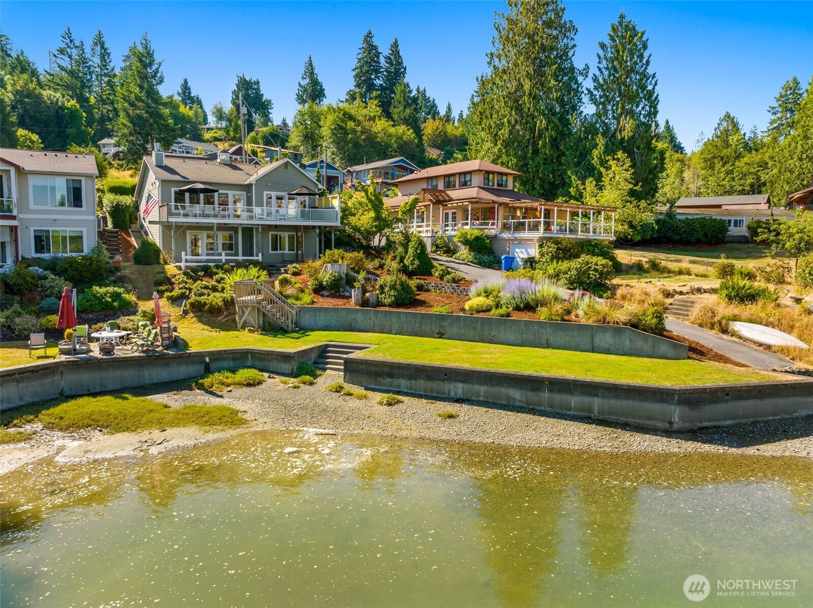 Breathe in the salt air and take in panoramic Sound and Olympic Mountain views from this inviting waterfront home. Thoughtfully updated with rich hardwood floors and a beautifully appointed kitchen featuring new quartz counters, the home offers comfortable main-level living with an easy, livable flow. Perfectly scaled, both the home and grounds allow you to enjoy waterfront living without the burden of constant upkeep. The flat, bulkheaded lawn is a rare and valuable feature, offering effortless access to the beach and an ideal setting for quiet mornings or sunset dinners by the water. Expansive north-facing views of the Olympics provide a stunning natural backdrop in every season. Located in the Griffin School District and part of the recreation-focused Carlyon Beach community, you’ll enjoy access to a marina, private beach, boat launch, clubhouse, park and dog park. Additionally, the peninsula offers a county park with water access, a fitness club with indoor pool, a driving range, coffee shops, a restauarant and more!