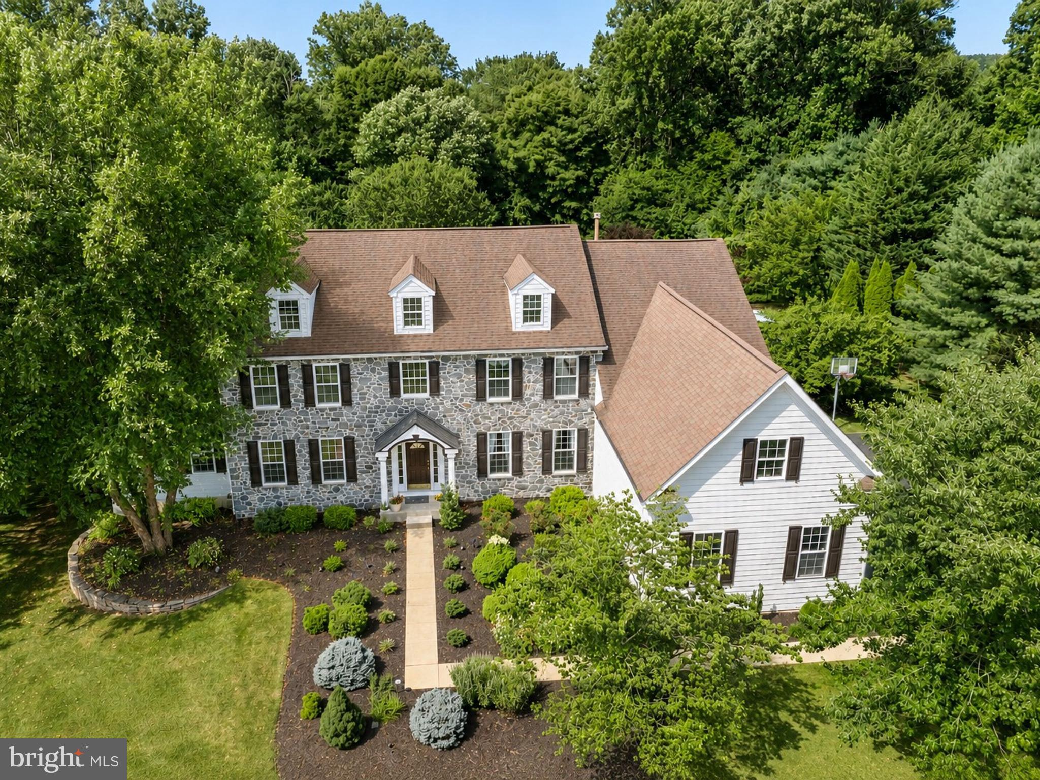 Tucked away at the end of a quiet cul-de-sac in the highly sought-after Haverhill Estates of Chester Springs, this exceptional stone-front colonial offers a rare combination of privacy, timeless architecture and resort-style living. Set on a premium 1.47-acre homesite backing to nearly 30 acres of protected open space with walking trails, mature woodlands and a gently flowing creek, this idyllic setting provides remarkable privacy and breathtaking natural beauty throughout every season.Offering 5,200 square feet on the first and second floors plus an additional 1,900-square-foot finished walk-out lower level, this meticulously maintained home was designed for both everyday living and grand-scale entertaining. Located in the award-winning Downingtown Area School District (Downingtown East) with access to the prestigious STEM Academy.A handsome stone façade and covered front porch welcome you into a dramatic two-story foyer flanked by formal living and dining rooms. The thoughtfully designed floor plan is filled with natural light and flows effortlessly throughout the home.An impressive entertaining room features a cathedral ceiling, floor-to-ceiling stone fireplace, billiards area, wet bar and access to the expansive rear deck spanning the length of the home. A private study with custom wood paneling and built-ins opens to the breathtaking two-story family room with vaulted ceilings, walls of windows and a floor-to-ceiling stone wood-burning fireplace.The expansive eat-in kitchen offers a center island, gas cooktop, double wall ovens, walk-in pantry and picturesque sink window overlooking the pool and backyard. A butler's pantry connects to the formal dining room, while a spacious laundry room, powder room and access to the three-car garage complete the main level.The luxurious primary suite features a recently renovated spa-inspired bath with soaking tub, dual vanities, oversized tiled shower, private water closet, expansive custom walk-in closet and adjoining sitting room. Three additional bedrooms include one en-suite and two connected by a Jack-and-Jill bath.The finished walk-out lower level provides exceptional flexibility with a spacious family room featuring a stone gas fireplace, screened porch overlooking the pool, fitness room, wine cellar, full bath and bonus room ideal as a fifth bedroom or office.A professionally designed IMAX-inspired home theater delivers an extraordinary cinematic experience with double-walled construction, Guilford’s of Main acoustic fabric throughout, R-30 insulation, specialized drywall, 4-way custom lighting, advanced surround sound and stadium seating with 11 leather reclining theater chairs.Outside, enjoy your own private resort featuring a heated in-ground pool with integrated spa and waterfall, plus a beautifully appointed cabana with full bar, built-in appliances, flat-screen TV and lounge area. The expansive backyard offers plenty of room for recreation and is enclosed with an invisible dog fence.Additional highlights include public water and sewer and new stone facade and three-sided James Hardie® siding.Conveniently located near Routes 113, 30, 202 and the Pennsylvania Turnpike, this remarkable property offers the perfect balance of peaceful surroundings and everyday convenience, with premier shopping, dining, parks and recreation just minutes away.