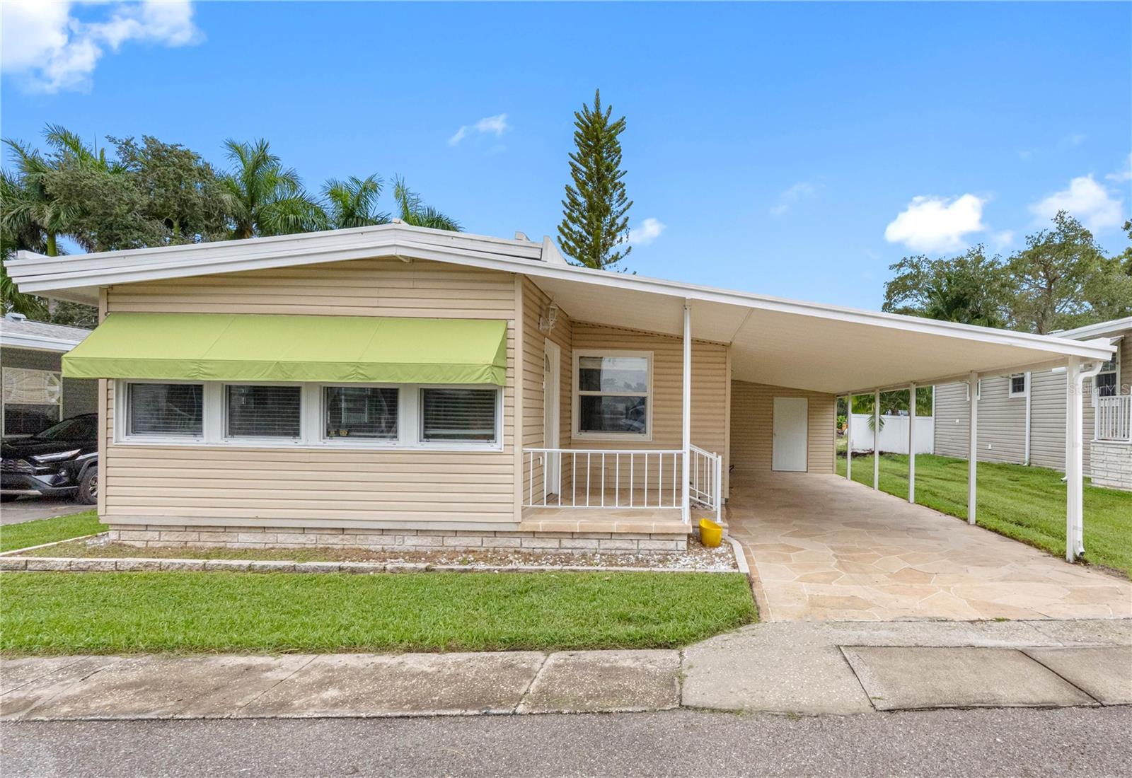 One or more photo(s) has been virtually staged. In the DESIRABLE, GATED 55+ PARK COMMUNITY of Doral Village, this FULLY REMODELED 2-bedroom, 2-bathroom home offers affordable living with the benefit of a resident-owned park, ensuring long-term stability and value for its homeowners. With NO LOT RENT and a low monthly maintenance fee of just $238, which covers water, sewer, lawn care, and garbage, this home combines comfort with cost efficiency. Spanning 1,004 square feet, the open floor plan has been thoughtfully updated throughout. The kitchen features STAINLESS STEEL APPLIANCES, NEW CUSTOM CABINETRY, and granite countertops. NEW PLUMBING, modern fixtures, and WATERPROOF LUXURY VINYL FLOORING add both function and peace of mind. The SPACIOUS PRIMARY SUITE offers a private bath with a walk-in shower, while the second bathroom includes a tub and new cabinetry. Additional highlights include a 2022 air conditioner, an extra wall unit in the bonus room, and a durable metal roof designed to last for many years. Practical features include a large two-car carport and an outside utility room. Step outside and enjoy the RESORT-STYLE AMENITIES of Doral Village, including a heated pool, hot tub, shuffleboard, billiards, and a wide array of social activities such as golf, bowling, card games, dances, and travel outings. This pet-friendly community is ideally located near golf courses, beautiful beaches, shopping, dining, medical facilities, and just 30 minutes to two major airports. Move-in ready and beautifully renovated, this home offers a vibrant, active lifestyle in one of the area’s most sought-after 55+ communities.