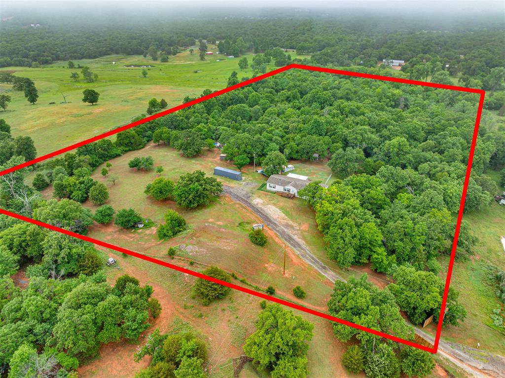 Escape to Your Own Private Retreat — 13 Wooded Acres with Home Tucked away from the world, this stunning 13-acre property offers the ultimate blend of natural beauty and outdoor living. At the heart of it all sits a comfortable 4-bedroom, 2-bathroom manufactured home — providing move-in ready living with plenty of space for family, guests, or a weekend getaway. Mature trees and lush woodland create a truly private sanctuary, with miles of established trails winding through the landscape — perfect for hiking, ATVing, or simply exploring your land. Wildlife enthusiasts and hunters will love the strategically placed trail cameras and hunting stands, with deer frequently roaming the property. Multiple ponds and a meandering creek add to the serene atmosphere while supporting the thriving ecosystem. The property features multiple sheds and storage structures, including one fully finished with electric and insulation — ready to serve as a workshop, man cave, she shed, hobby space, or additional storage for equipment and gear. When the day is done, unwind on the spacious covered back patio — ideal for entertaining or simply soaking in the sights and sounds of nature surrounding you. An above-ground storm shelter provides added peace of mind for Oklahoma weather. Properties like this — offering a ready-to-live-in home, genuine seclusion, recreational opportunity, and natural beauty all in one — are a rare find. Whether you're seeking a full-time residence, hunting retreat, or peaceful escape from the hustle, this land delivers it all.
