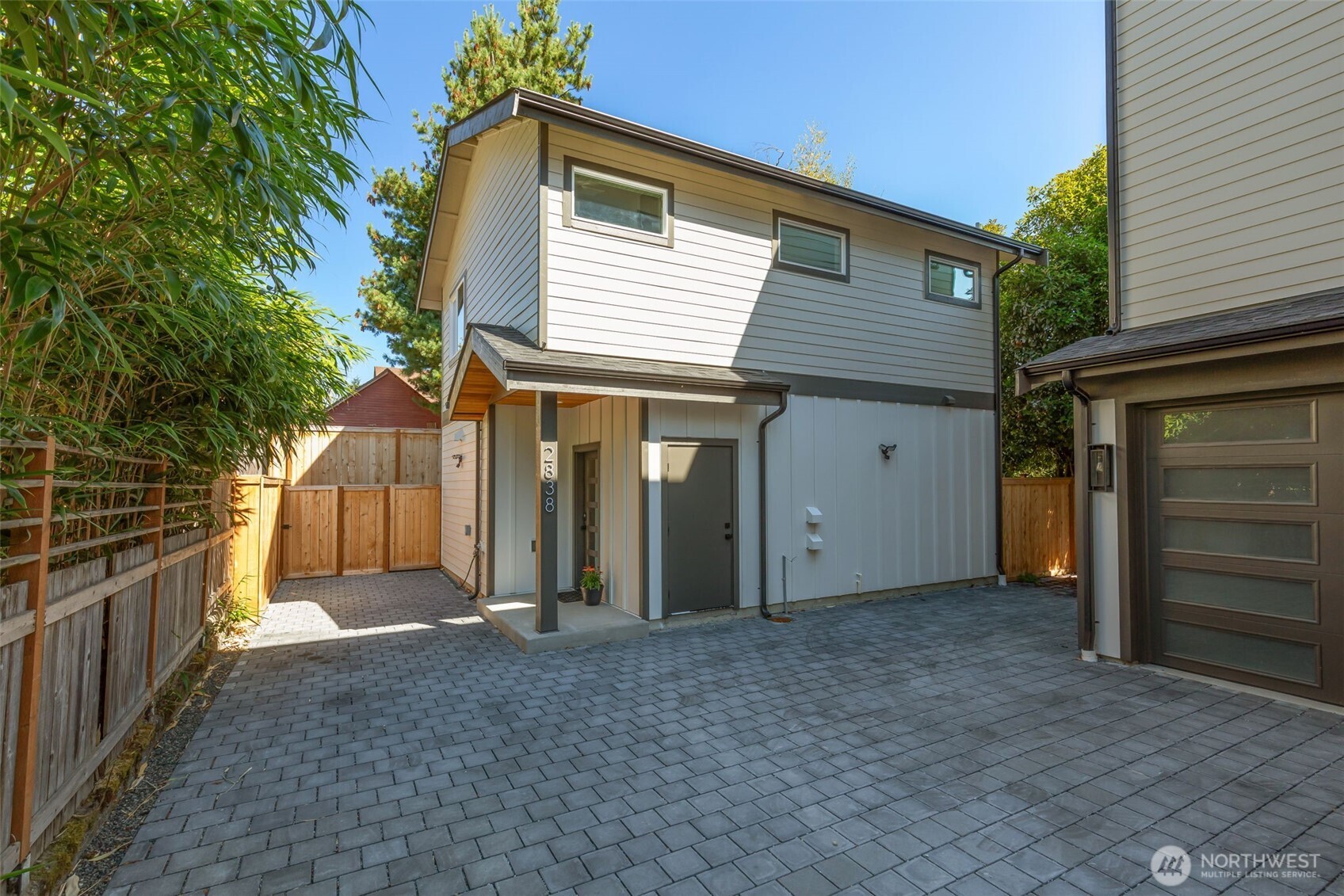 Tucked back from the street for added privacy, this thoughtfully designed detached residence offers the best of both worlds: the ease of lock-and-leave living without the typical condo assessment concerns. Located on a quiet street in Sunset Hill, you're just blocks from Sunset Hill Park, where sweeping views of Puget Sound, the Olympic Mountains, and the islands await.Inside, the open-concept main floor is designed for everyday living and entertaining, with a spacious kitchen island, cozy fireplace, and sliders opening to a private patio and yard—perfect for summer dinners, pets, gardening, or simply relaxing outdoors. A convenient powder room completes the main level. Upstairs, you'll find two bedrooms, including a primary suite with dual sinks and a generous walk-in shower. The second bedroom and full hallway bath offer flexibility for guests, a home office, or roommate living. Convenient bedroom-level laundry, mini-splits for heating and cooling, and an off-street parking pad add to the everyday ease. Enjoy a peaceful neighborhood setting just minutes from the energy of downtown Ballard. Spend weekends exploring neighborhood restaurants and shops, browsing the Sunday Farmers Market, visiting the Ballard Locks or Nordic Museum, and taking advantage of everything this vibrant community has to offer. A stylish, low-maintenance home with space to live, work, and enjoy the best of Ballard.