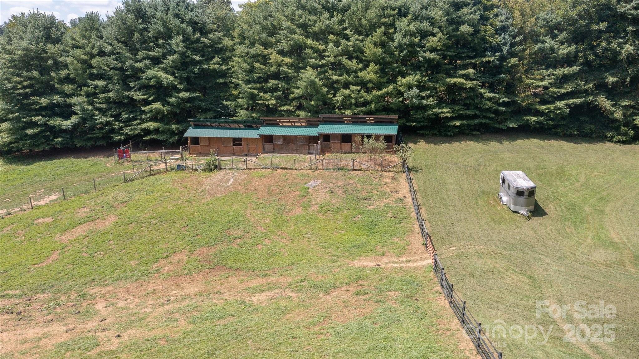 Horse Haven in Cane Creek Valley!  Dreaming of the ultimate equestrian lifestyle? Welcome to your private paradise 9.09 acres of mostly fenced pastureland nestled in the Cane Creek Valley. Imagine your horses grazing freely across open fields with a creek running through the property, adding to the natural charm. Equestrian-Ready & Designed for Wellness This property features a spacious 6-stall barn, multiple paddocks for personalized care, and a thoughtfully designed track system to promote healthy movement and happy horses. It's the ideal setup for any equine enthusiast! Privacy, Panoramic Views & Country Charm. Enjoy the best of peaceful country living with picture-perfect mountain vistas as your backdrop—just 20 minutes to downtown Asheville and only 5 minutes to the local brewery and grocery. A prime homesite is perfectly positioned to soak in the scenery every day. Don’t miss your chance to own a rare piece of equestrian heaven in the heart of Fairview’s Cane Creek Valley.