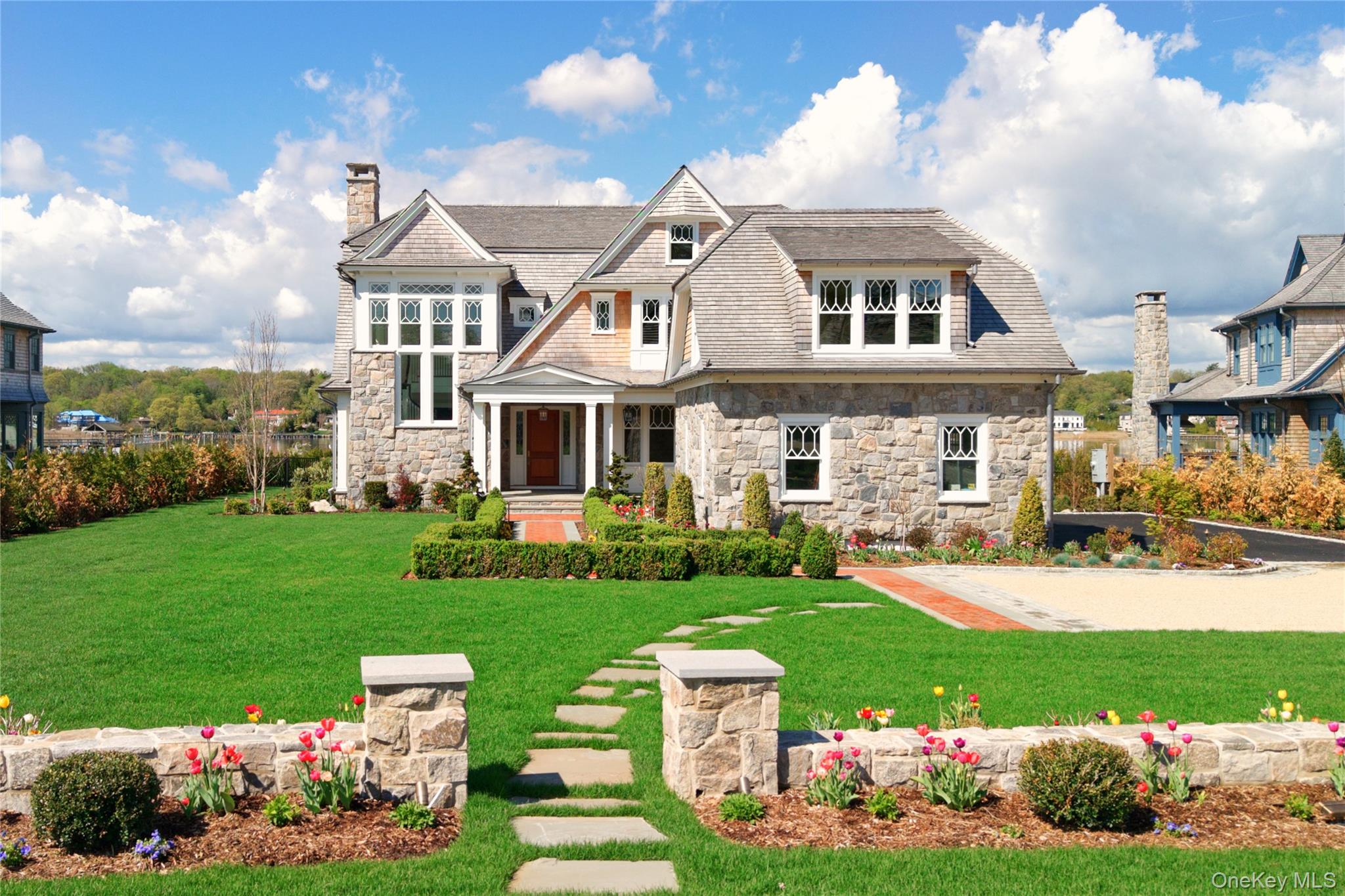 Extraordinary new construction on Manhasset Bay spanning approximately 6,700 square feet, defined by exceptional craftsmanship and sweeping, unobstructed water views. A dramatic stair tower sets the tone. The main level features a formal dining room, living room with fireplace, and a chef's kitchen with dual islands, connecting to the great room and informal dining area. A  walk-in pantry, private office, and mudroom with custom built-ins are complemented by two powder rooms. Upstairs, a gallery leads to a striking primary suite with a private deck overlooking the bay, spa bath, and expansive closet. Three additional en-suite bedrooms, a laundry room, and an entertainment lounge complete the level. An unfinished third floor offers future potential. Outdoor living includes a covered porch and fireplace, Lynx outdoor kitchen with grill, sink, and refrigerator, and a heated, saltwater Gunite pool with spa and gas firepit, all oriented with breathtaking bay views. Unobstructed water views, with permit for dock.