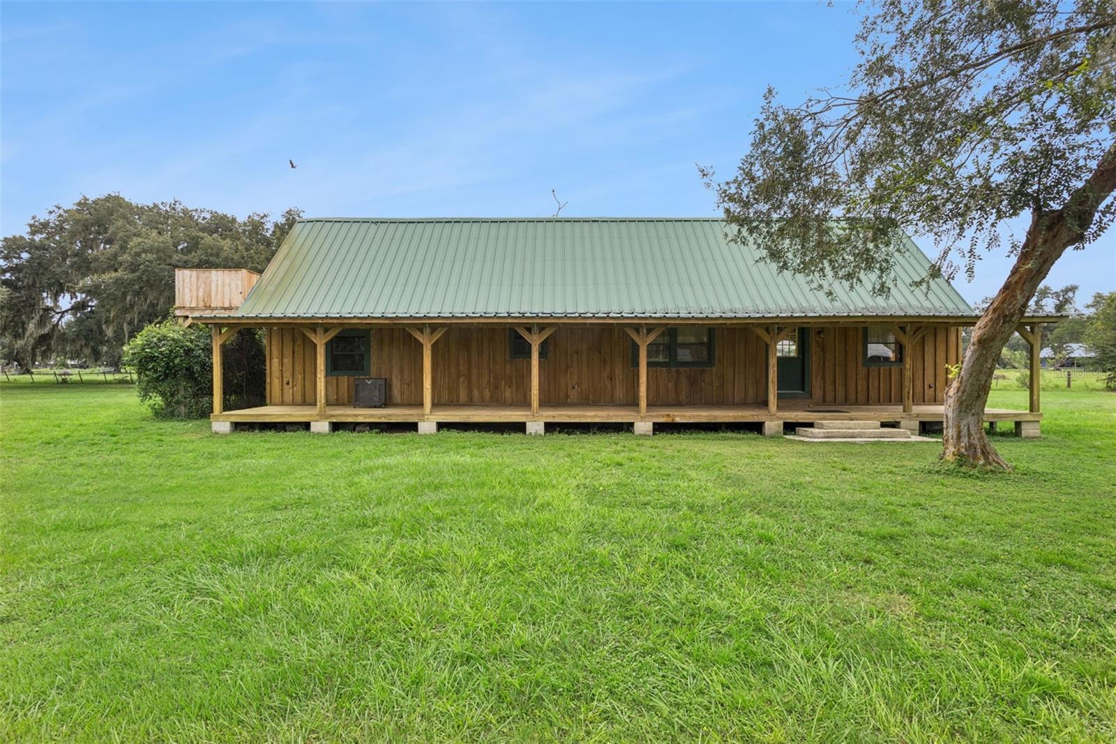 NOT JUST A HOME. A HOMESTEAD. Some properties are built. Others are crafted. Tucked away on six acres in Groveland, this one-of-a-kind Florida retreat has a story you simply won't find in a typical home. Hand-built by the craftsman owner using wood harvested from the very land it sits on, this remarkable home showcases concrete and block footings, cypress construction/ framing, and pine wood floors. The result is a home rich in character, craftsmanship, and authenticity; Being sold by the only person whose ever owned it. This isn't something you can simply order from a builder's catalog. It's the kind of place you have to experience to truly appreciate.A beautiful green metal roof, natural (cypress) wood exterior, and two expansive covered porches set the tone before you even step inside. The two-bedroom, one-bathroom layout offers a cozy yet spacious atmosphere, with a huge open-concept living room and kitchen that creates an inviting place to gather, entertain, or simply enjoy the slower pace of country living. You'll also find a loft upstairs, a walk-in closet, and a dedicated interior laundry room, bringing everyday practicality to this distinctive retreat.Upstairs, the beautiful loft with more than 200 square feet of additional space adds another dimension to the home. Whether you envision another bedroom, creative studio, reading retreat, or a quiet place to unwind, the possibilities are as unique as the property itself. Step outside onto the loft's private elevated deck and take in the peaceful surroundings, mature trees, and open countryside.Outside is where the homestead lifestyle truly comes alive. Six acres provide a beautiful combination of wide-open grassy spaces and majestic oak trees draped in Spanish moss. Enjoy your morning coffee on one of the home's two covered porches, spend afternoons exploring the land, or watch the evening light settle over your own slice of Florida countryside. With NO HOA, there's room to imagine a lifestyle beyond the ordinary, whether that means gardening, outdoor recreation, extra storage for your toys, or simply enjoying the space and privacy that acreage provides.Located in Groveland, with Clermont, Minneola, and Mascotte all within the surrounding area, this property offers a peaceful rural setting while keeping everyday conveniences and commutes within reach.Six acres. No HOA. Handcrafted character that cannot be duplicated. This is more than a place to live. It's a place to put down roots, create something of your own, and embrace a different way of life. Come experience the craftsmanship, the land, and the story for yourself. Some homes have features. This one has a legacy.
