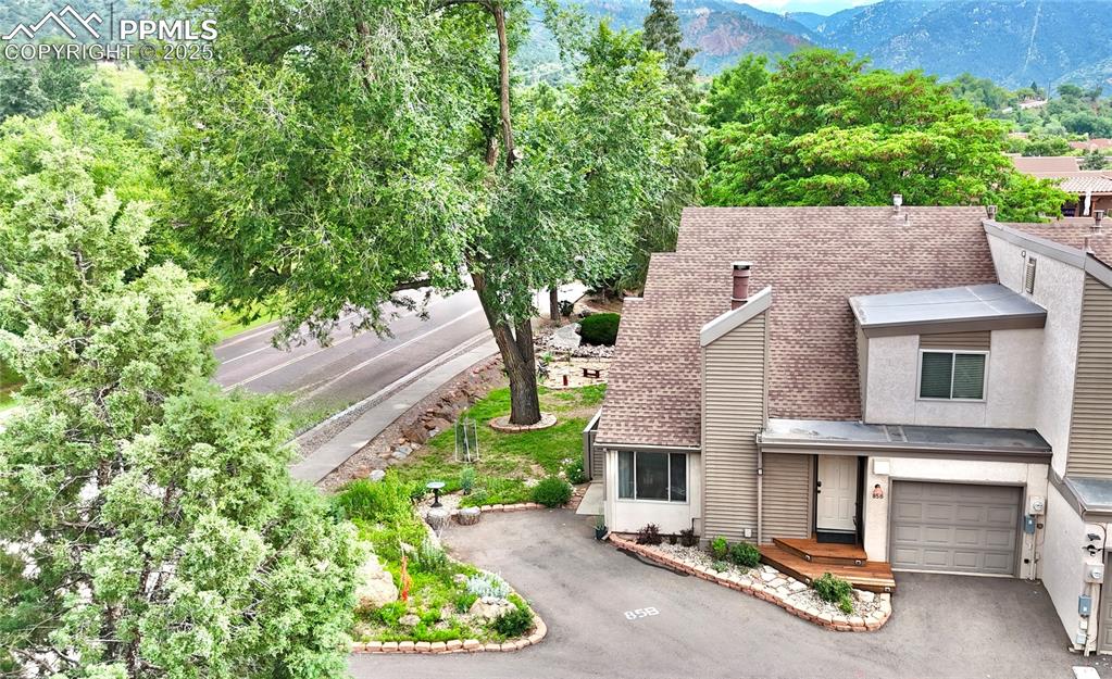 Turn-Key Manitou Springs Townhome at an incredible price - RENTAL BASEMENT INCOME POTENTIAL!  3 Bed, 3 Bath super-cute and move-in ready, this unique townhome sits right at the base of Pikes Peak— a short distance from the iconic Manitou Incline, Red Rock Open Space & Garden of the Gods. .  Inside: custom design details set this home apart. The light-filled living room features vaulted ceilings, corner bench seating in front of high-quality vinyl windows.  Your gas fireplace adds cozy comfort during Colorado winters.  Open kitchen boasts ample cabinetry with smoked-glass doors for a clean, modern look, plus a breakfast bar & lots of accent lighting.  NO CARPET anywhere — this entire home features low-maintenance tile & wood flooring throughout.  Upstairs: Oversized primary suite includes a large walk-in closet.  Main-level laundry hookups enable a stackable washer/dryer beside a pantry, while the basement features a full laundry room with a brand new HVAC system & water heater.  Washer & dryer included.  Basement suite offers flexible use—rent it out, host guests, or enjoy it as a second living space.  Rare for this complex, this unit includes green space outside all windows; attached garage & a deeded parking space right at the front door!  Just minutes to downtown Manitou Springs & Colorado Springs, near the Manitou Pool, shops, restaurants & parks — free Manitou shuttles & transit to CO Springs are a couple blocks away; you can literally hike into the Rockies & to the top of Pikes Peak from your porch.  Live in the whole home or offset your mortgage with the downstairs rental — this one is a must-see!