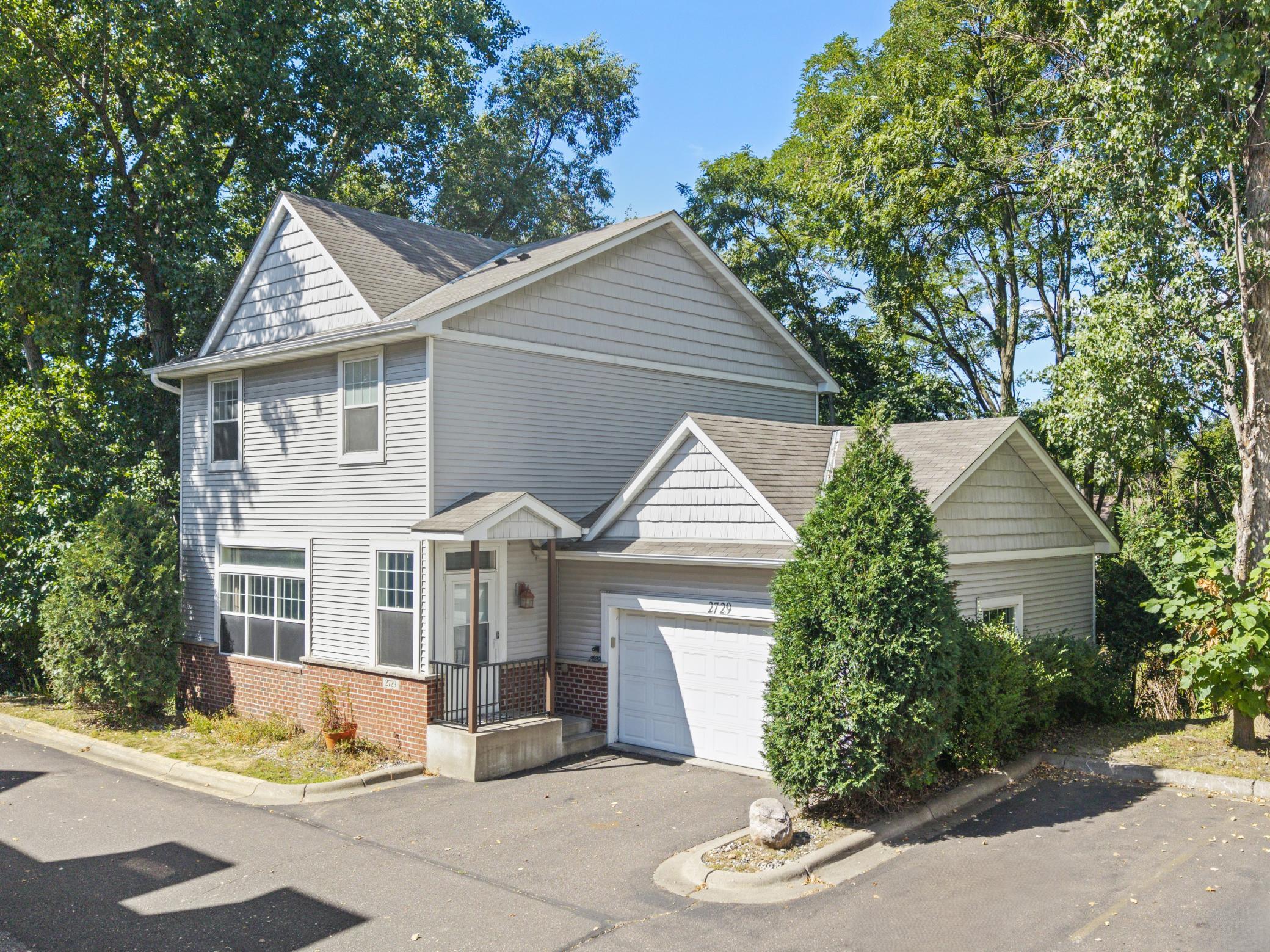 A little privacy, a lot of convenience! Tucked against peaceful wooded space, this well-cared-for home offers bright, open living spaces, abundant updates, and plenty of room to spread out.Enjoy tall ceilings, oversized windows, a gas fireplace, deck with wooded views, three comfortable bedrooms, and a versatile walkout lower level with a spacious family room, rec space, and included pool table!Add an attached two-car garage, guest parking, and a convenient location near parks, shopping, dining, schools, golf, and major roads, and you have a home that truly checks all the boxes!