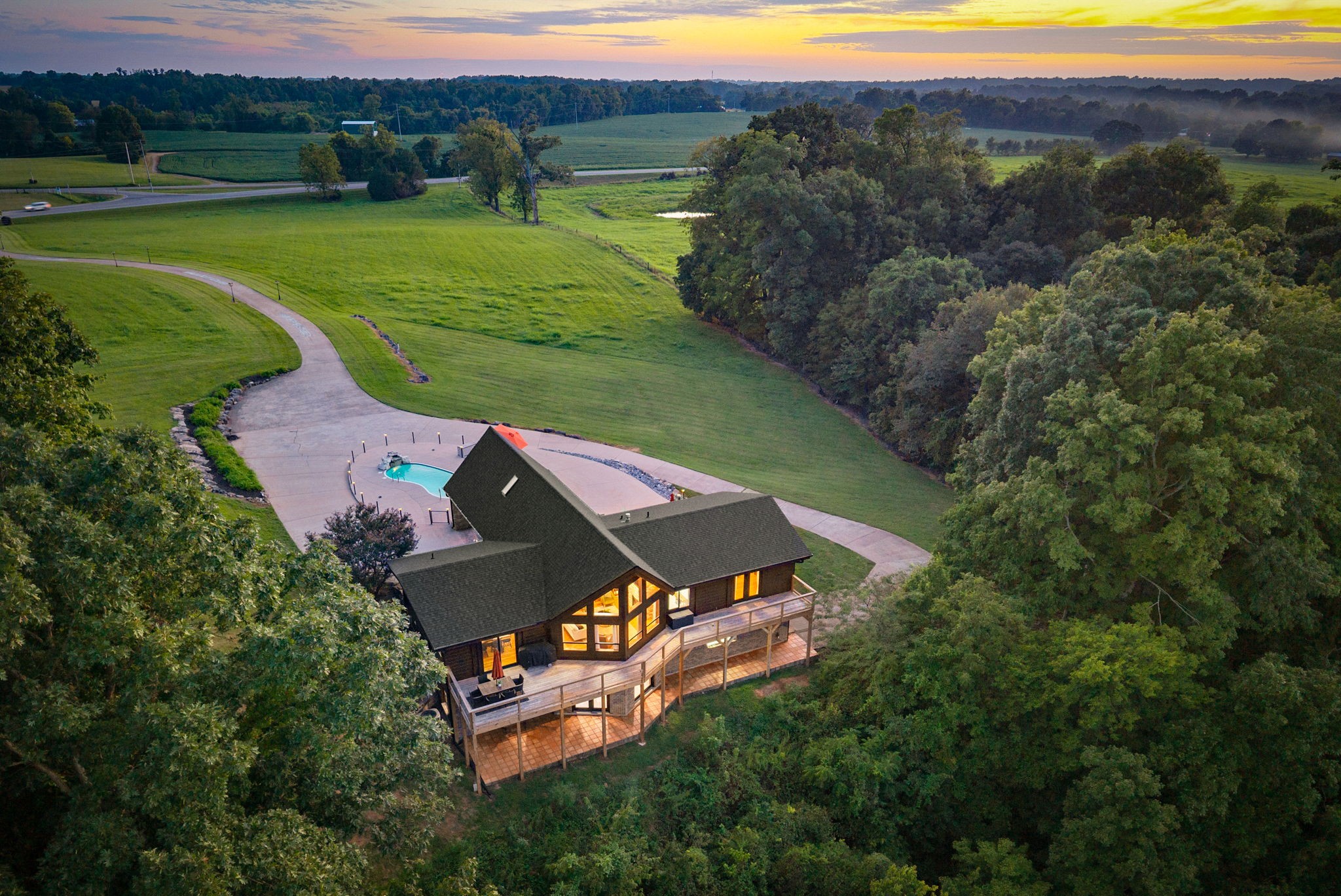 For the first time ever in the public eye, this beautifully renovated property is ready for its next chapter. Privately positioned on 10.23 acres, the home offers sweeping farmland and bluff views, an in-ground pool and a versatile layout designed for multi-generational living with county taxes only!A paved drive leads to the covered carport and circle drive. Inside, dramatic A-frame ceilings and expansive windows fill the main living area with natural light while framing the incredible setting beyond. The kitchen features a large island, adjoining dining area, freshly painted cabinetry, updated hardware and fixtures, stainless steel appliances and access to the newly constructed wraparound deck.The main-level primary suite opens to the deck through French doors and features a renovated bath with marble tile, dual vanity, spa-style shower and architectural accents reclaimed from a local church. A second bedroom and full bath complete the main level, while upstairs offers an additional bedroom and loft-style bonus space.The walkout lower level functions as a complete second living space with its own kitchen, living and dining areas, bedroom, full bath, private entrance and covered terra-cotta tiled patio, creating true flexibility for extended family, guests or independent living.Outside, the acreage offers privacy, room to roam and at least two additional potential build sites, creating an opportunity for a private family compound or additional residences, subject to applicable approvals.