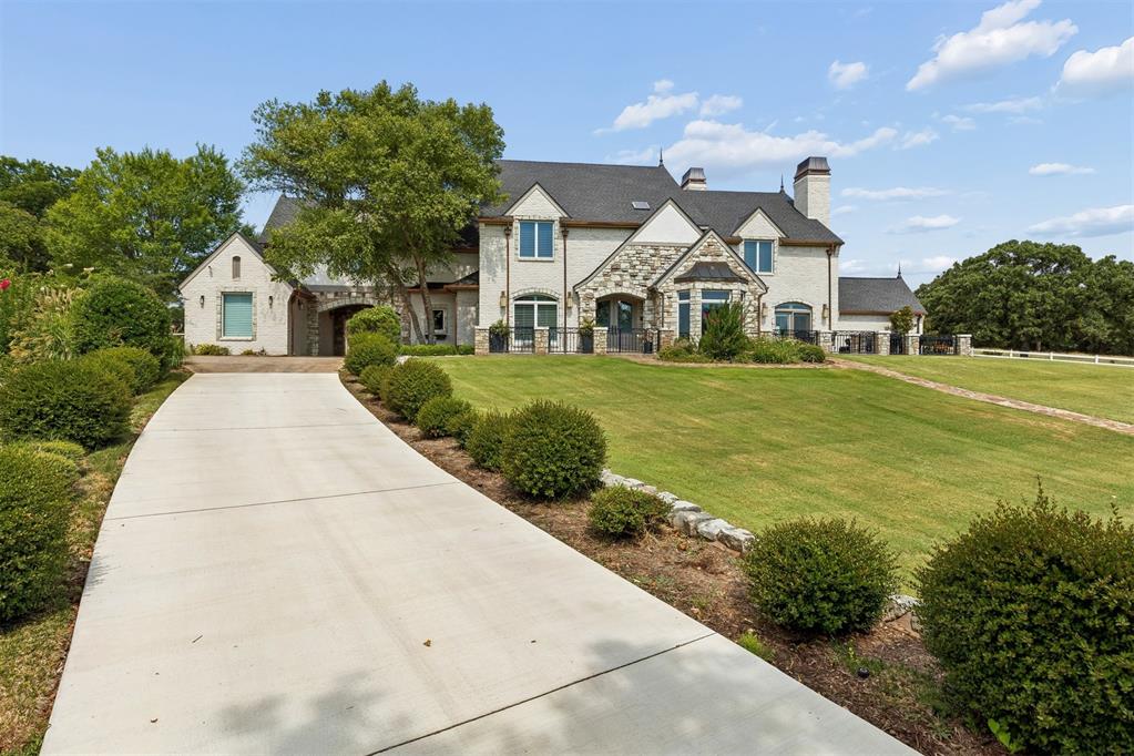 A rare opportunity to own an exceptional gated estate on more than 17 picturesque acres, offering privacy, luxury, & resort-style living in a truly special setting.  A winding drive framed by mature trees & manicured grounds creates an impressive sense of arrival the moment you enter.Home has been extensively updated & meticulously maintained, with major investments already completed throughout. Improvements include newer HVAC systems, three tankless water heaters, impact-resistant roof, extensive hardwood flooring, new carpet, remodeled bathrooms, updated lighting & fixtures, newer pool equipment, & numerous mechanical & infrastructure upgrades.The main living area is filled with natural light & features soaring ceilings, hardwood floors, custom built-ins, a dramatic stone fireplace & striking reclaimed-wood beams that add warmth & architectural character. The open-concept kitchen is designed for both everyday living & entertaining, with an oversized center island, expansive serving bar, generous seating & abundant workspace. The dining & living spaces overlook an incredible outdoor retreat featuring a swimming pool, outdoor kitchen, & multiple covered entertaining areas. Beyond the pool, a private stocked pond with its own dock provides a peaceful setting for fishing, relaxing, or simply enjoying the views.A fully insulated & climate-controlled 24' x 52' shop provides exceptional space for vehicles, equipment, hobbies, storage, or recreation.The primary suite & guest bedroom are located on the main level, with three additional bedrooms & multiple living areas upstairs. A separate private living space with its own bedroom & bathroom offers added flexibility for extended family/guests.With 17+ acres of gated privacy, a stocked pond & private dock, resort-style outdoor living, a climate-controlled shop, & extensive updates throughout, this home offers a combination of setting, amenities, & quality that is truly one of a kind. Pasture area fenced for horses.
