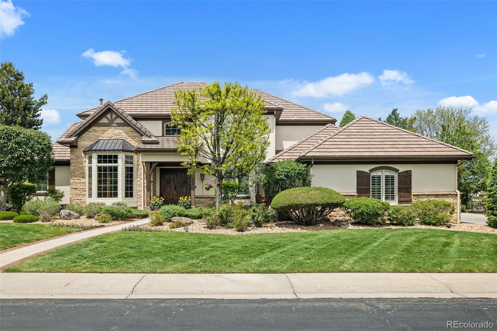 Experience luxury living in this exceptional custom home featuring breathtaking downtown Denver views, backing to open space, and surrounded by scenic trails. Perfectly situated on a cul-de-sac within a prestigious gated community offering private pool access, sport courts, and incredible neighborhood events. Step inside to impressive natural wood flooring and a grand open layout designed for both elegance and comfort. The executive office with double doors sits at the front of the home, across from the elegant formal dining room. The stunning family room showcases soaring ceilings, a dramatic fireplace, Sonos surround sound, and a wall of newer windows with Hunter Douglas remote-controlled blinds that perfectly frame the spectacular views. Flow into the gourmet kitchen featuring a large island, two dishwashers, abundant gorgeous cabinetry, walk-in pantry, and picturesque exit to the stamped concrete patio. The luxurious main-floor primary suite features a cozy sitting area, spa-inspired bathroom with sunken tub, oversized shower, dual vanities, and an expansive walk-in closet. Convenient main-level laundry adds to the thoughtful design. Upstairs offers a beautiful loft overlooking the family room, along with three spacious bedrooms, each featuring attached bathroom and generous sized closets. The finished basement provides an expansive rec room, stylish wet bar area, space for a gym, theatre area, and extensive storage options. Outside, the backyard retreat is truly impressive - it backs to open space with incredible views and exceptional privacy. Completing the home is an oversized side-load 3-car garage offering outstanding curb appeal. This extraordinary home combines luxury, functionality, and unmatched views in one remarkable property. Don't miss out - see it today!