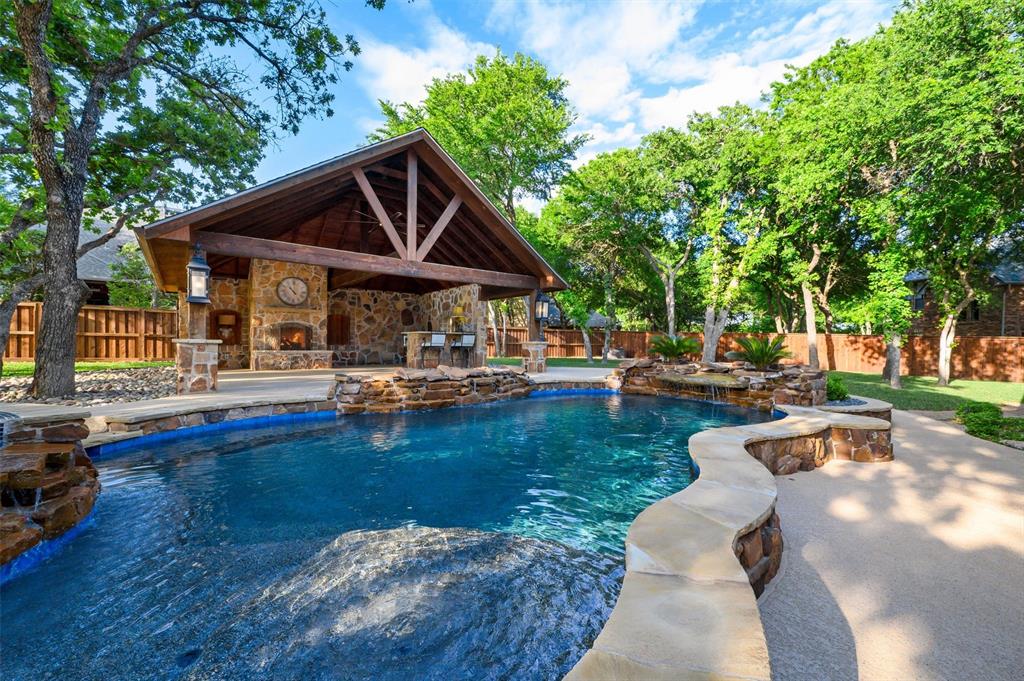 Luxury living on over half an acre, centered around an unforgettable backyard oasis. Originally crafted by a custom builder as his personal residence, this exceptional home showcases a level of quality, intention, and detail rarely found. Tucked within one of Keller’s most sought-after neighborhoods, the residence is a seamless blend of refined elegance and effortless livability. Thoughtfully designed and impeccably maintained, it offers light-filled interiors, beautifully appointed living spaces, and a layout that transitions gracefully from everyday comfort to elevated entertaining. The home features four split bedrooms and a versatile flex space that may serve as a fifth bedroom, private office, or media retreat. The primary suite is a true sanctuary, highlighted by a recently reimagined bath with sophisticated, on-trend finishes that evoke a spa-like experience. Beyond the back doors lies the defining centerpiece of the property—an extraordinary outdoor retreat designed to rival luxury resorts. A breathtaking pool, expansive entertaining areas, and a stunning cabana create an atmosphere that is both elevated and inviting. Whether hosting unforgettable gatherings or enjoying serene evenings under the Texas sky, this setting delivers a lifestyle few properties can offer. Additional highlights include an oversized walk-out attic storage room, thoughtfully designed to accommodate seasonal décor and more with ease. Perfectly positioned within top-rated Keller ISD and moments from premier shopping, dining, and major conveniences, this residence presents a rare opportunity to experience refined living in one of the area’s most desirable locations. This is not just a home—it is an experience. Photos simply cannot capture its full presence. Schedule your showing today for the full experience. Safe in garage stays with home.