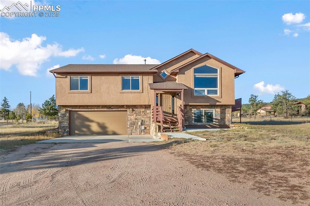 Did you know that Lovelll Gluch is just down the Road, and you are within Walking Distance to the National Forest. Then you get the Spacious 3-bedroom, 3-bath home on 1.79 level, fenced acres with a stunning Pikes Peak view! 2,168 sq ft with open living and dining areas, a functional kitchen - including a pantry. A large primary bedroom with an adjoining bath and double-vanity is ideal for morning or nighttime routine. Two bedrooms across the hall allow for little ones to be close with their own space. The finished lower level offers flexible living space. An attached two-car garage provides ample space for storage or other hobbies. Enjoy the deck and yard, which provide plenty of space for entertaining, pets, or gardening. Located within walking distance to schools and just minutes from shopping, dining, and all town amenities. This is a great opportunity to enjoy peaceful, spacious living with in-town convenience!