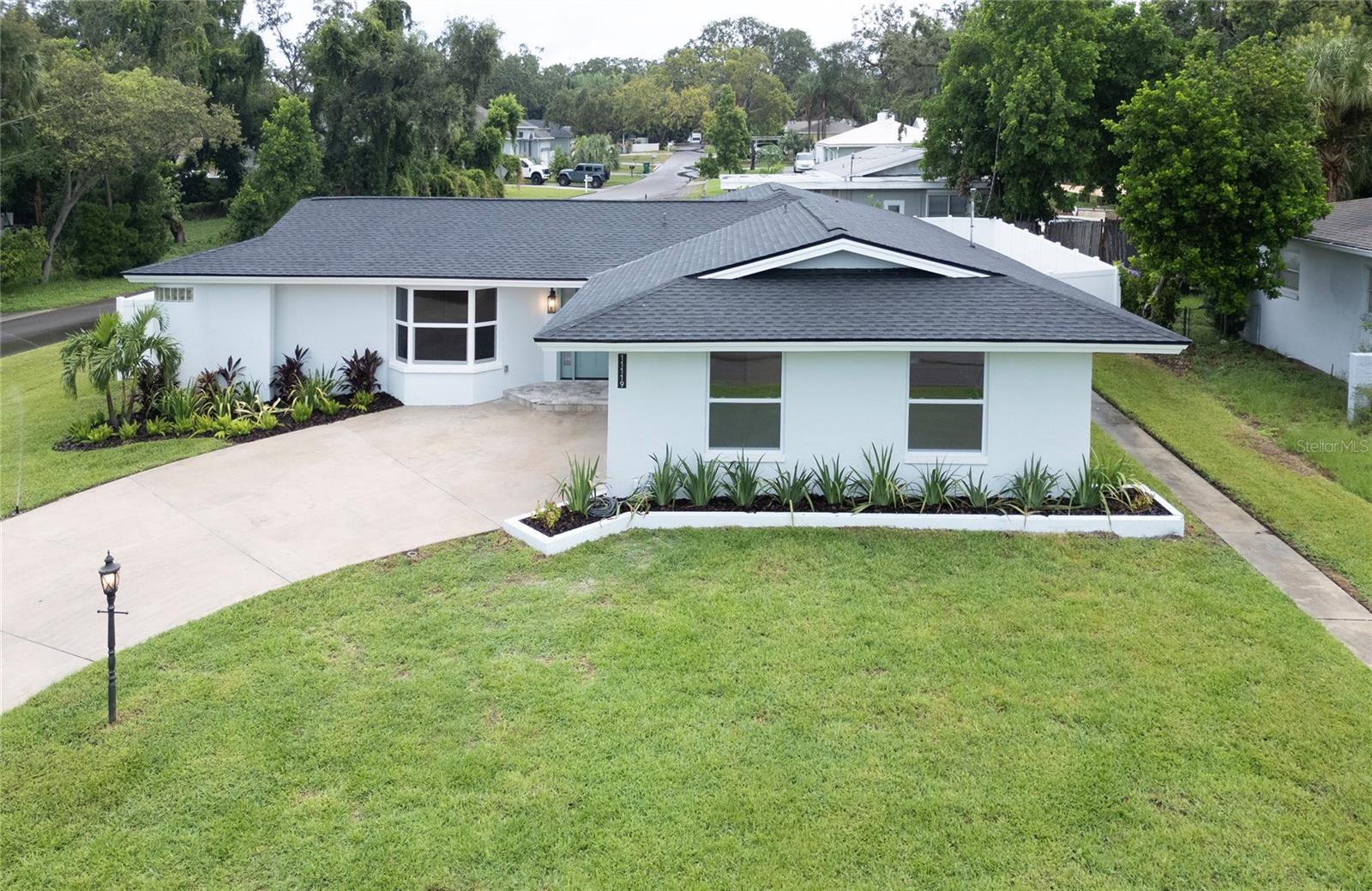 Welcome to this fully renovated Florida ranch, located just 1 mile from Florida Gulf Beaches in St. Petersburg. Situated on a spacious quarter-acre corner lot, it is outside the flood zone, in a non-evacuation area, with no damage from previous hurricanes —a rare combination this close to the Gulf.

The exterior has been completely updated with new sod, landscaping, irrigation system, roof, soffit, fascia, new white vinyl fence, new hurricane-impact windows, and hurricane-impact garage door with opener, along with fresh exterior paint. A fully fenced yard provides privacy, while the 300 sq. ft. paver patio creates the perfect space for outdoor entertaining.

Inside, the home lives like new construction, no one has occupied it since the top-to-bottom renovation. The redesigned open split-bedroom floor plan offers four bedrooms and two bathrooms, with just under 2,600 sq. ft of living space, not including a massive 650 sq. ft garage with plenty of room for your toys or a workshop. A large formal living room and formal dining room flow seamlessly into the open kitchen, anchored by a striking 14-foot island. The kitchen also features a dry bar with beverage fridge with custom wood shelves, stainless steel appliances, built-in drawer microwave, quartz counters, under cabinet lighting, crown molding and abundant storage and prep space.

The interior showcases engineered hardwood floors throughout, all new solid-core wood doors, new custom wood closet systems and closet doors, new trim, new hardware, new lighting, new electrical outlets, new rocker switches/dimmers and fresh paint. Each bedroom is outfitted with a custom wood closet system, including a 12x6 custom built wood wrap around closet system in the master suite.

The master retreat includes 2 large windows with tons of natural light, a large custom built walk-in closet, an en suite bath with dual vanities, LED lighted mirror, a glass-enclosed shower with marble and mosaic tile, and two shower heads—one rain shower and one standard. The guest bath is equally impressive, boasting custom tile work, dual-sink vanity, gold fixtures, sconces, a bathtub, and a private toilet closet. Additional highlights include new French doors, new ceiling fans, upgraded hardware, and a dedicated laundry room with wash sink, quartz counters, and built-in cabinetry.

This home combines the charm of a classic ranch with the peace of mind of a full modern rebuild. Its prime location places you just minutes from the best Beaches on the West Coast of Florida, local shops, dining, and vibrant Gulf Coast living, all while enjoying a quiet residential neighborhood.
