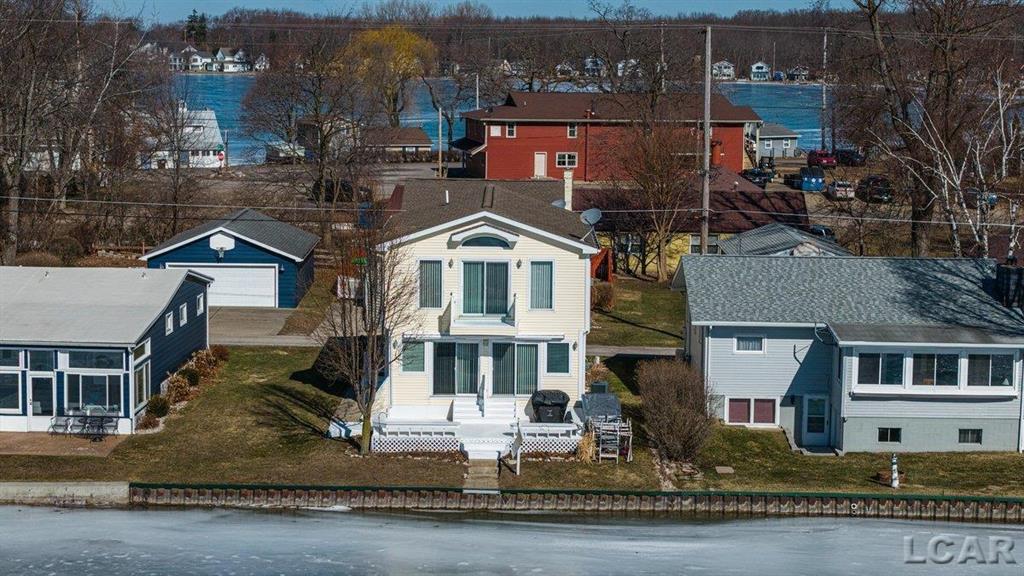 Welcome to year round lakefront living on All Sports Round Lake! This 4 bedroom, 2 bath home features an open concept living area filled with natural light, highlighted by sliding doors leading to the lakefront deck which is perfect for entertaining and enjoying the water views.  The primary bedroom is a true retreat, offering a gas fireplace, sliding door to a private balcony, large windows, and spectacular lake views. The property is further complemented by a 2 bedroom, 1 bath guest apartment located above a large 2 car garage, ideal for guests, extended family, or additional income potential.  Designed to maximize lakefront living, this home offers seamless indoor-outdoor flow, abundant natural light, and breathtaking views throughout. Located on Round Lake in the Irish Hills, you can enjoy all sports recreation, year round enjoyment, and the charm of the Manitou Beach lake community while making lake life memories to last a lifetime!