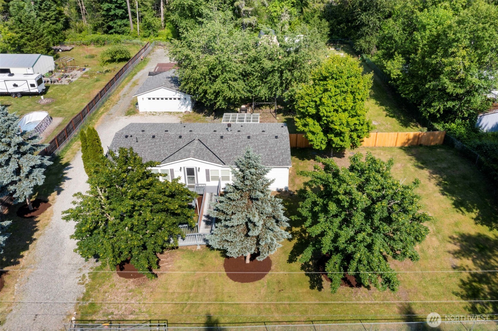 Charming country-style living on over an acre in Graham! Recent updates include newer roof, quartz counters, new cabinets, LVP flooring, fresh paint, new furnace, trim & doors. The great room offers connectivity to the spacious kitchen featuring stainless appliances, newer cabinets & quartz counters. Enjoy a cozy wood-burning fireplace on those chilly nights-A/C for the hot summer days. Step out onto the enclosed sun porch or the patio with morning coffee. Enjoy the fully fenced acreage with mature landscaping, a detached 2-car garage, RV parking w/ water & power, raised garden beds for your green thumb, chicken coop, & two large sheds for all your gear. A perfect blend of rural living & close-to-town convenience near Graham & Puyallup.