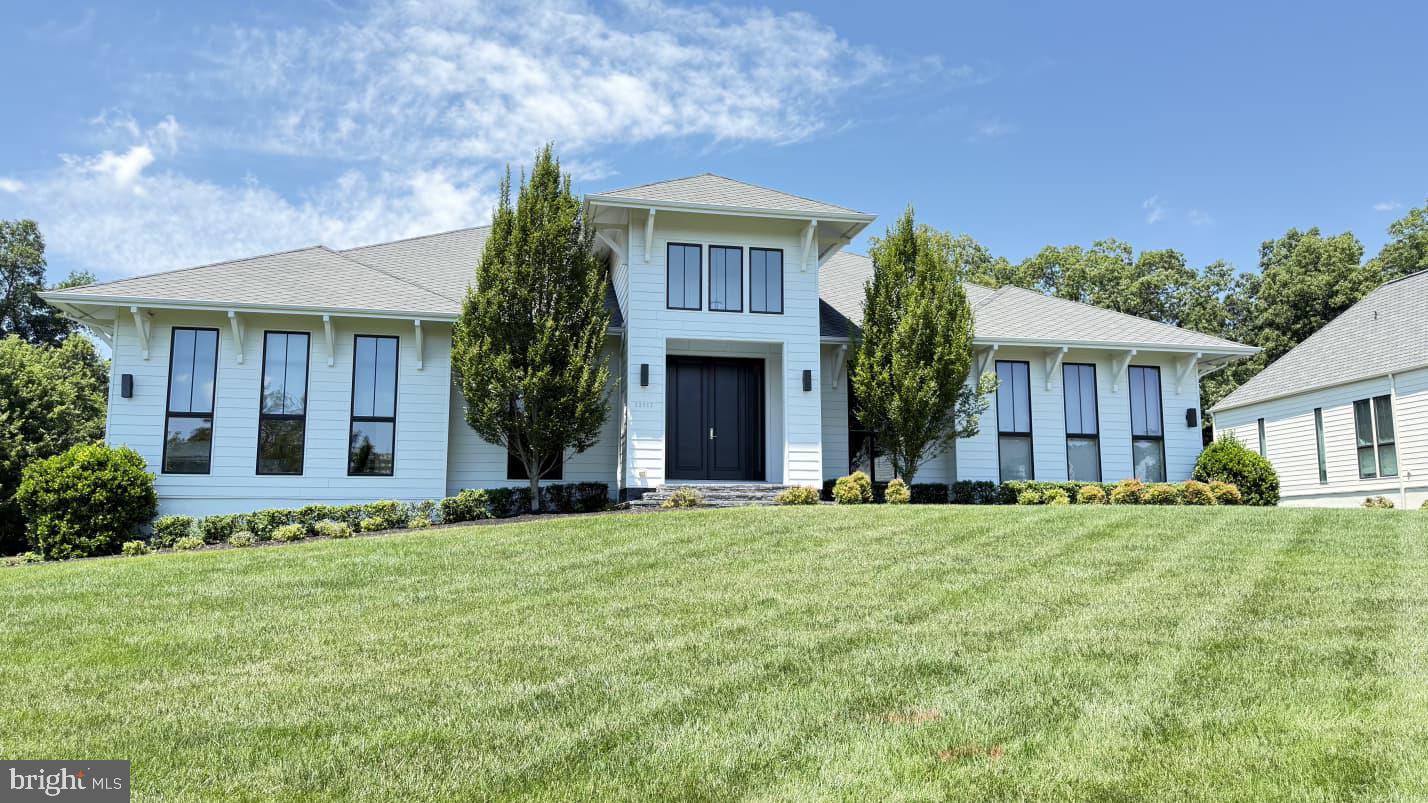 Experience European-inspired luxury in this exceptional 5-bedroom LINE K by Piet Boon residence in The Grant at Willowsford. Showcasing world-renowned contemporary design, this home features soaring 12-foot main-level ceilings and a spectacular rear wall of oversized windows that floods the living spaces with natural light while framing serene outdoor views. Wide-plank flooring, designer lighting, custom millwork, and a striking contemporary fireplace create a sophisticated yet inviting atmosphere. The chef's kitchen is beautifully appointed with premium Viking appliances, an oversized waterfall island, full-height stone backsplash, and expansive pantry storage.Enhanced with over $180,000 in premium upgrades, this home is as functional as it is luxurious. The fully finished lower level offers four exceptional spaces, including a private in-law suite, a second home office, a fitness room, and a dedicated home theater with two-row stadium seating, a built-in AV rack, and pre-wiring for a projector and an immersive 6.3.4 Dolby Atmos surround sound system. The luxurious owner's retreat features motorized, remote-controlled shades and a spa-inspired bath. Smart home technology includes app-controlled Bose whole-home audio in the great room, patio, owner's bath, and gym, a Ubiquiti WiFi system, and Lutron smart lighting throughout. Outside, enjoy a professionally installed 10-zone irrigation system and seamless indoor-outdoor living. A rare opportunity to own one of Willowsford's most architecturally distinctive, technology-forward luxury homes.This home sits in the award-winning Willowsford Community, surrounded by Loudoun’s wine country. Enjoy resort-style amenities—beach-entry pools, splash pad, lodge, fitness center, dog parks, sledding hill, tree house, and even a farm stand/CSA. Minutes from Brambleton and One Loudoun for dining, shopping, and entertainment, plus nearby Hanson Regional Park (257 acres!), farmers markets, Wegmans, wineries, and breweries. Convenient to Dulles Airport, Silver Line Metro, Tysons/DC, and top-rated Loudoun County schools.