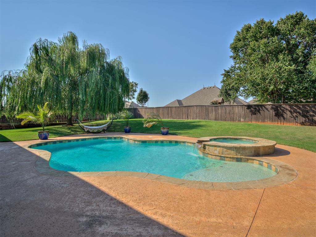 Resort-Style Multi-Generational retreat in Edmond! This extraordinary home offers over 5,000 sq. ft. of luxury living designed for entertaining, relaxing, and multi-generational comfort. With 4 bedrooms, 3.5 bathrooms, 2 living areas, 2 dining spaces, a game room, private theatre room, and a designated office, there’s room for every lifestyle. The thoughtful 3-way split floorplan provides both privacy and flexibility. The primary suite features its own private living area and spa-like bath, creating a true retreat. The second suite also includes an attached living space, perfect for extended guests, in-laws, or a quiet getaway. With five walk-in closets, storage is abundant throughout the home. Designed with both elegance and function in mind, the spacious kitchen and dining areas set the stage for gatherings of any size. Entertain in style with multiple living spaces, host family movie nights in the theatre room, or enjoy fun and games in the large game room. The designated office adds even more flexibility, ideal for working from home in comfort. Step outside to your own private paradise. The resort-style heated pool with an overflowing hot tub is the centerpiece of an entertainer’s dream backyard. But don't miss the amazing gas fireplace in a huge entertainment space and a great outdoor kitchen! Whether you’re hosting parties, relaxing under the stars, or soaking up the sun, this outdoor space delivers year-round enjoyment. A 4-car garage completes the package, providing room for vehicles, hobbies, or storage. From its resort-style amenities to its versatile floor plan, this home is more than a residence—it’s a lifestyle statement. Don’t miss your chance to experience this exceptional Edmond property that blends luxury, function, and fun all in one!