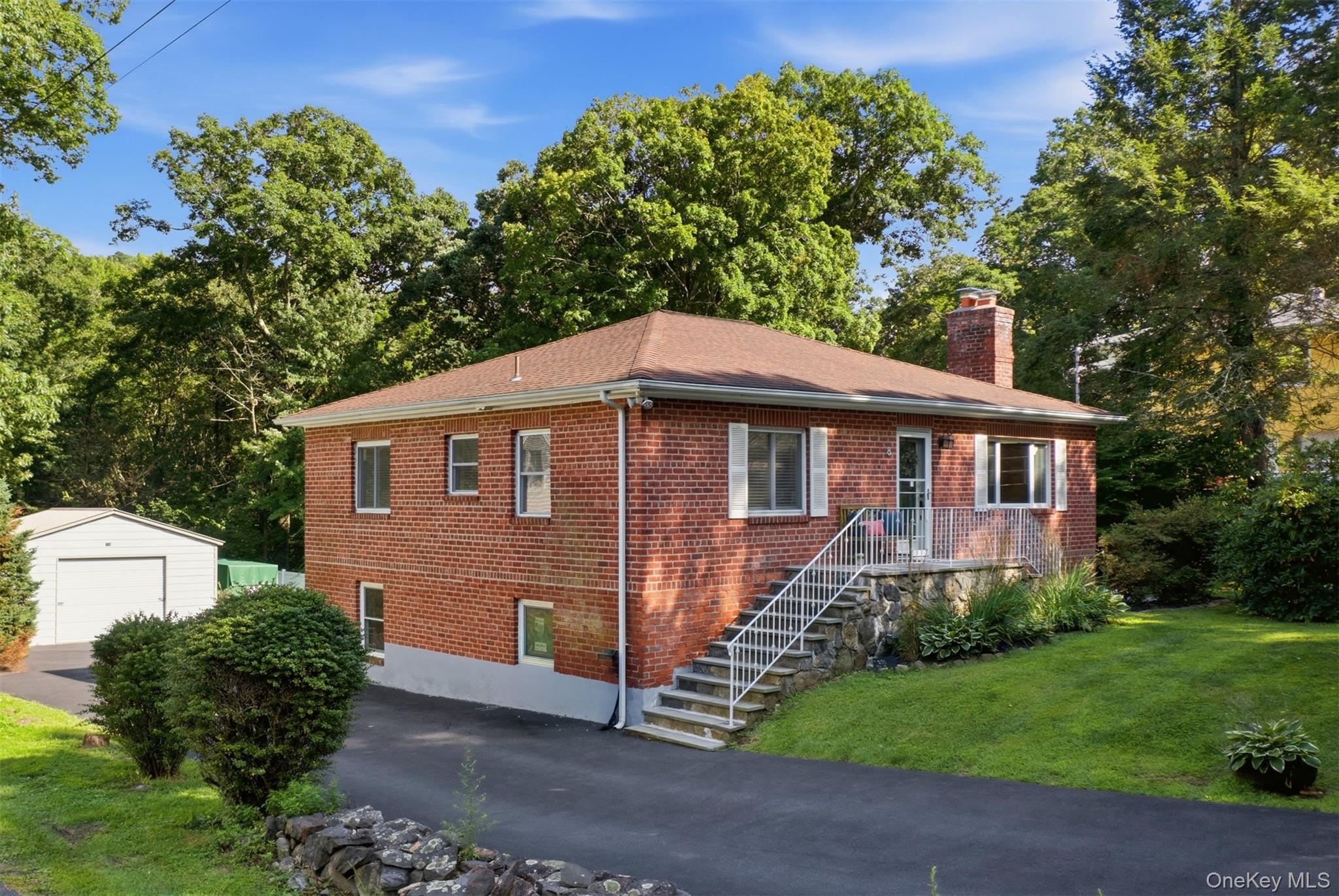 Charming, Well-built Red-Brick Home Offering Two Bedrooms while Living Like a Three-bedroom. Situated in a quiet, low-traffic neighborhood within the private Roaring Brook Lake community, the property is near approximately 100 acres of protected land. Residents enjoy lake rights and access to the natural beauty and recreational opportunities of the picturesque 115-acre lake, which measures approximately 3.5 miles around. Owned by the same family for 60 years, this lovingly cared-for home features hardwood floors, wide-plank prefinished maple flooring and a wood-burning stove in the living room, marble tile flooring in the entryway, fresh interior paint, and an updated marble bathroom. The renovated kitchen includes granite countertops, a tumbled-marble backsplash, tile flooring, and stainless-steel appliances approximately two years old. The roof is approximately nine years old and features 40-year architectural shingles. The walk-out lower level includes a recreation room with a full bathroom, along with nearly 1,000 square feet of unfinished flex space ready to be customized as a home office, gym, hobby room, workshop, or additional storage. A deck overlooks the large backyard, offering plenty of space for outdoor entertaining. Additional features include a detached two-car garage and an 8-by-10-foot storage shed. Just one minute from the Taconic State Parkway, the home is conveniently located for an easy commute to New York City.