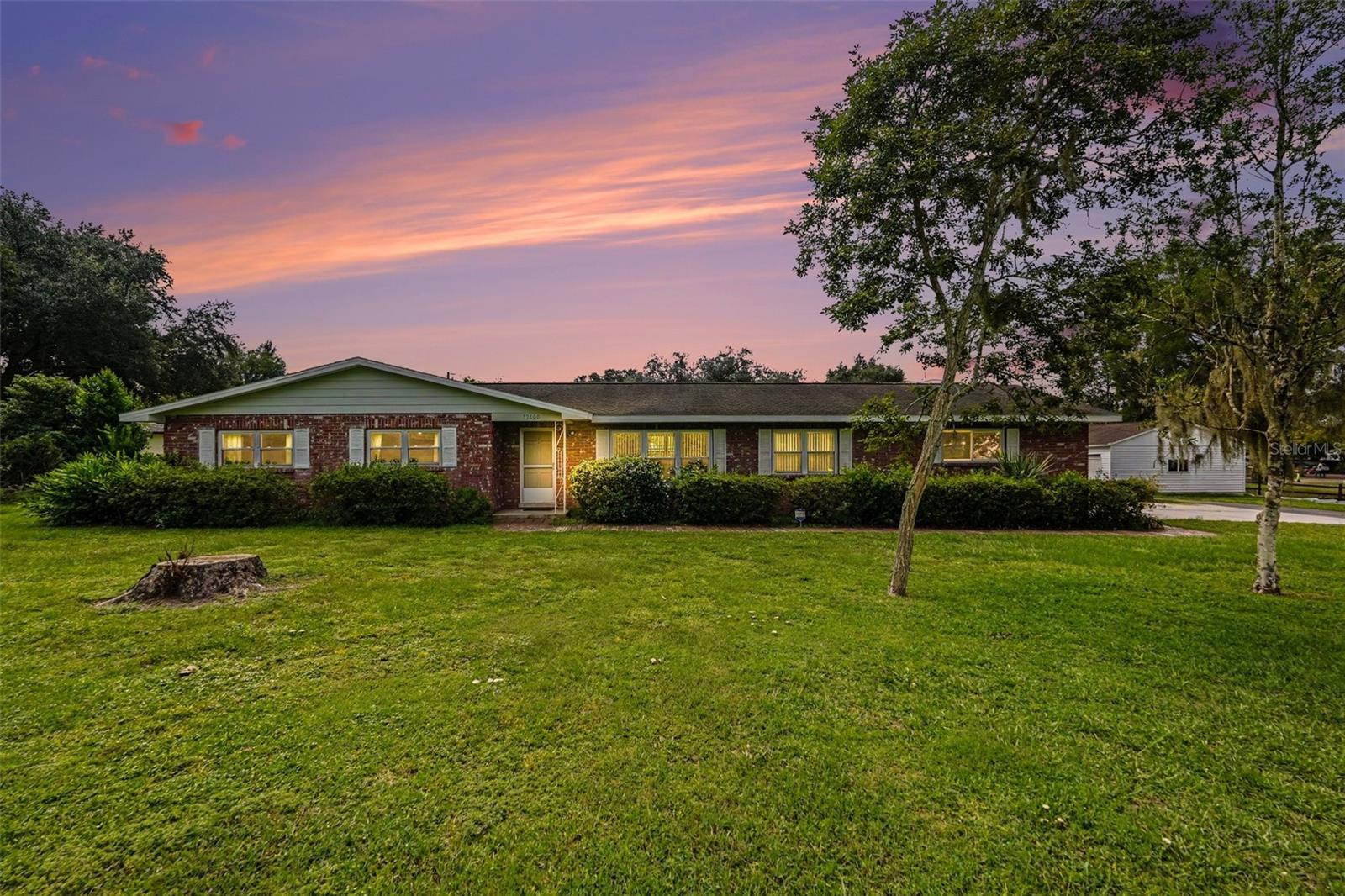 Virtually Staged. Welcome to Your Florida Home! Picture this: you pull in drive through your own private road to your home. In the back you see your toys and RV under their own covered carport, the RV has its own powered spot, and the only thing you hear is the breeze through the mature trees. Welcome to Zephyrhills, where this 3-bed, 2-bath block home sits on a fully fenced acre with space for everything you've been wanting.Outside is where this property shines:A full pool, ready for Florida afternoonsPowered car and RV portsTwo detached garages with power, for a workshop, hobby space, storage, or the toysOpen, cleared entrance lined with mature treesFully fenced for privacy and flexibilityInside, you get a solid canvas. Block construction, oversized bedrooms (rare in newer homes), and double-pane windows give you a strong foundation to make it your own design. The roof was replaced in 2012 and the AC in 2014, both in working order with no known leaks. You can put your money into the finishes you want instead of the big-ticket items.The numbers make it easier to say yes:No HOA and no CDD fees.Flood Zone X.1,586 sq ft.2 detached powered structures totaling 1,292 sq ft.1 acreYou're close to shops, schools, and parks, with easy access to Tampa and Wesley Chapel. Multiple down payment assistance programs may be available, and eligibility varies by buyer, so ask me whether you qualify.Properties with this much land, this much covered parking, and no HOA don't come around often. Book your private showing today and see what you could build here.
