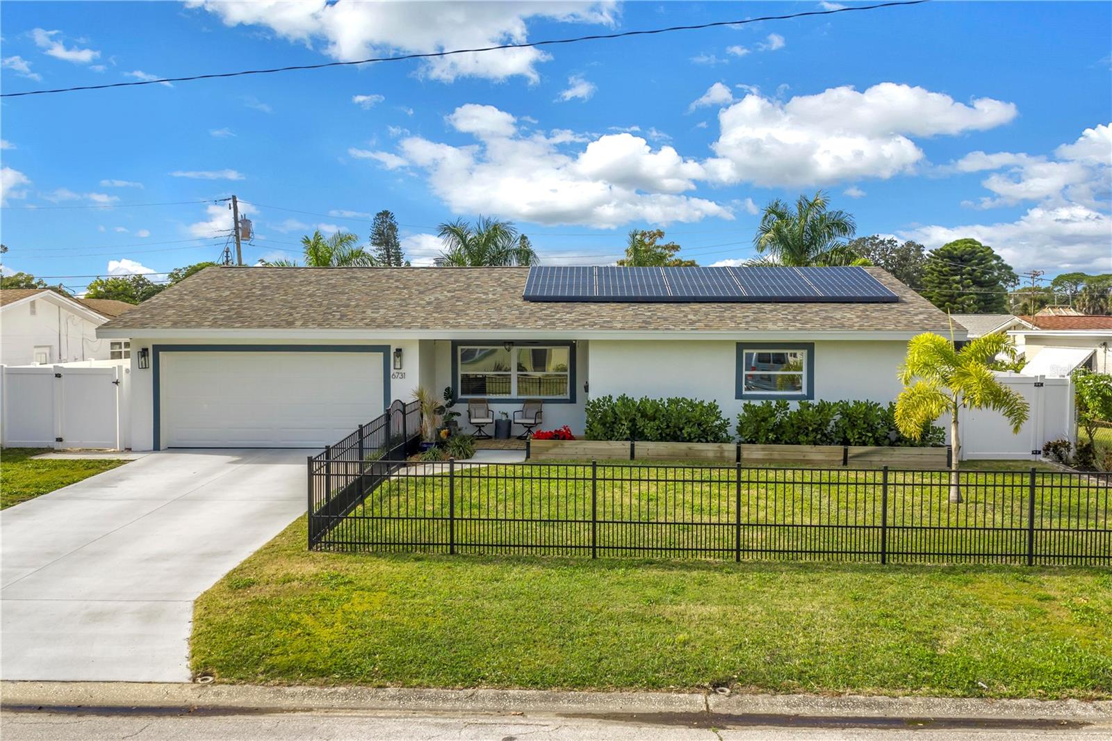 This home is truly resort living!  Located just minutes from vibrant downtown St. Petersburg, this beautifully renovated home has so much to offer!  Situated in desirable Flood Zone X, the property was fully renovated between 2019–2020 and is truly move-in ready.  The open, split-bedroom floor plan is perfect for entertaining and easy living. The stunning kitchen features Samsung stainless steel appliances, granite countertops, skylights, and a seamless flow into the living and dining areas. A custom dry bar with wine refrigerator adds the perfect touch for hosting. The family/dining room features a sleek electric fireplace and opens through sliding doors to the expansive outdoor patio.  Both bathrooms have been thoughtfully updated and include Bluetooth speaker/light features. All four bedrooms are generously sized.  This home is packed with high-value upgrades, including a new roof (2019), hurricane-impact windows and doors, a hurricane-rated garage door, natural gas connection, NEST thermostat, solar panels (paid in full)  for low electric bills, a workshop, and a well pump for irrigation. The two-car garage includes two EV charging plugs and a freshly painted floor.  Step outside to your fully fenced, private backyard oasis with large palm trees that offer full privacy, pavers, and turf ideal for a dog run. The show-stopping solar-heated pool features a sun shelf, deep-water bench, iridescent tile accents, and two water features. Outdoor amenities continue with a pergola equipped with a projector and screen, a retractable awning, and a dedicated sauna and cold plunge, making this the place for perfect for year round entertaining and enjoyment.  With its unbeatable location, extensive upgrades, and resort-style amenities, this exceptional home offers the best of Florida living—just unpack and enjoy.