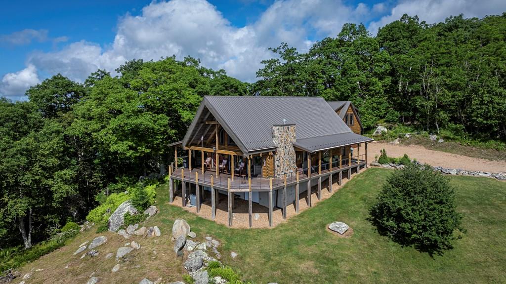 Log Home and Acreage Plus Recreational River Tract w/ 100 Feet on New River! This 4 bedroom 4 bath log home on 13.97 acres has astounding, high elevation, southern views. Large windows and extensive, low maintenance decking and porches make this the ideal place to enjoy nature. Enjoy sunrise and sunset from the same deck. There are multiple springs and trails throughout the property and the community with almost 300 acres of common area to enjoy including the “Pinnacle Point” at 4450 feet of elevation. Large, mature timber and gigantic rock outcroppings, Mountain Laurel, Rhododendron and abundant wildlife let you know that you are in a real Appalachian Forest. The extremely well maintained log home features wormy Chestnut custom cabinetry, a large, open great room complete with large, rock fireplace. There is plenty of room for family and guests with 4 bedrooms and 3 baths in main home and a large apartment over the 2 car garage complete with mini kitchen and bath that will sleep 5 or more. This property is located in a private, gated community with underground utilities and paved roads. This community is located in the heart of Grayson County close to the New River, New River Trail, hiking, biking, equestrian trails, trout fishing and more! In addition to high elevation, mountaintop views, this property conveys with a .58 acre recreational New River Tract!! You'll have the best of both worlds with this oversized lot with 100 feet of frontage on the New close to the convergence of the New River and Little River. It has 3 motor home/camper pads, 2 concrete. Water and electricity are onsite. If you enjoy the outdoors, this is the place to be. Locally this property is a short drive to Galax Virginia, West Jefferson NC and wonderful golf courses. This is an easy drive from the metropolitan areas of Charlotte, Winston-Salem and the Research Triangle area. This home conveys fully furnished.