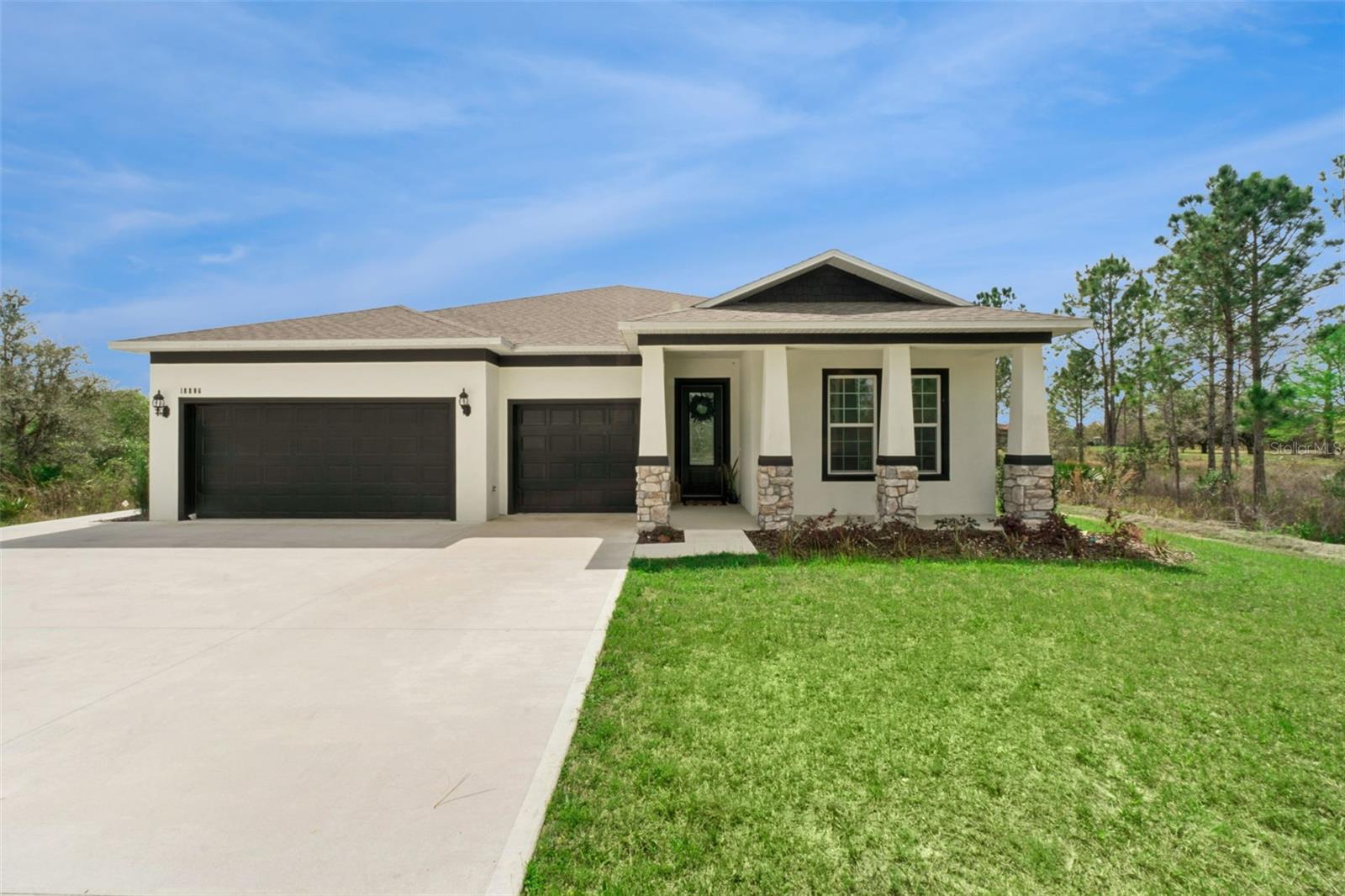 Welcome to your dream home in Wedgefield, where modern luxury meets peaceful country living. Situated on a full acre surrounded by mature trees, this elegant new construction residence offers the perfect blend of space, privacy, and thoughtful design.Step inside to high tray ceilings, custom flooring, and upscale finishes that set the tone from the moment you enter the open foyer. The split-bedroom floor plan provides both comfort and functionality, with two spacious guest bedrooms located at the front of the home and connected by a convenient Jack-and-Jill bathroom.The heart of the home is the expansive open living area, where the living room, dining space, kitchen, and breakfast nook flow seamlessly together. The designer kitchen is a showstopper, featuring custom cabinetry, stone countertops, and beautiful tile throughout—perfect for everyday living and entertaining alike.Tucked away at the back of the home for maximum privacy, the primary suite offers a quiet retreat with plenty of space to unwind. A standout feature of this home is the private-entry fourth bedroom suite, complete with an additional flex room equipped with a kitchenette (sink and countertop). This versatile space is ideal for multigenerational living, long-term guests, or a private home office setup.Additional highlights include a large laundry room, a 3-car garage, and the peace of mind that comes with brand-new construction. Step outside to enjoy the covered lanai and an extended paver patio—perfect for entertaining or relaxing while taking in the serene, tree-lined surroundings.Located in the desirable Wedgefield/Rocket City area of East Orlando, this property offers the feel of country living while remaining close to everything. Enjoy shopping and dining at Waterford Lakes Town Center (about 20 minutes away), explore nature at Hal Scott Preserve (under 10 minutes), or head to Cocoa Beach (approximately 35 minutes) for a day by the ocean. You’ll also appreciate convenient access to Lake Nona’s Medical City, UCF, Orlando International Airport, and major highways including SR-528 and SR-520.If you’ve been searching for room to breathe without giving up city convenience, this exceptional home delivers it all. Whether you're looking for your forever home or a private retreat with flexibility, this is a must-see opportunity.