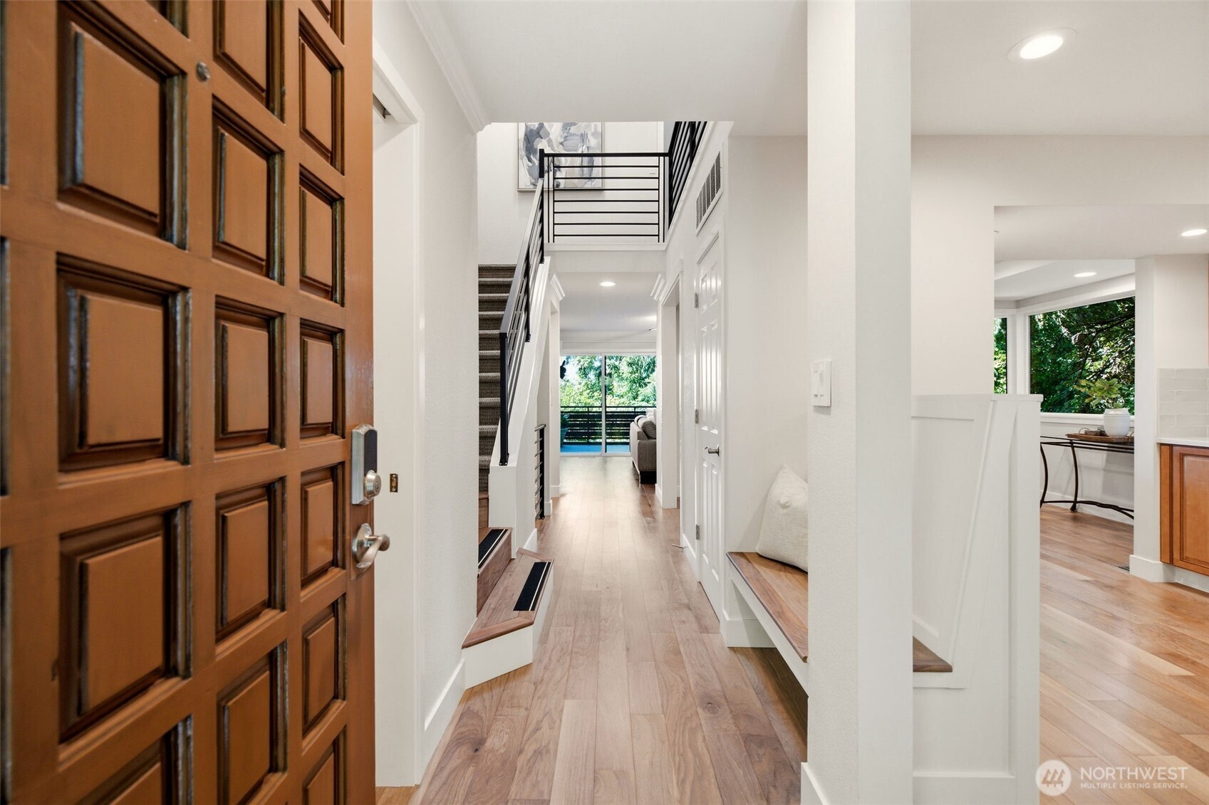 Bright foyer with soaring ceilings and warm hardwood flooring.