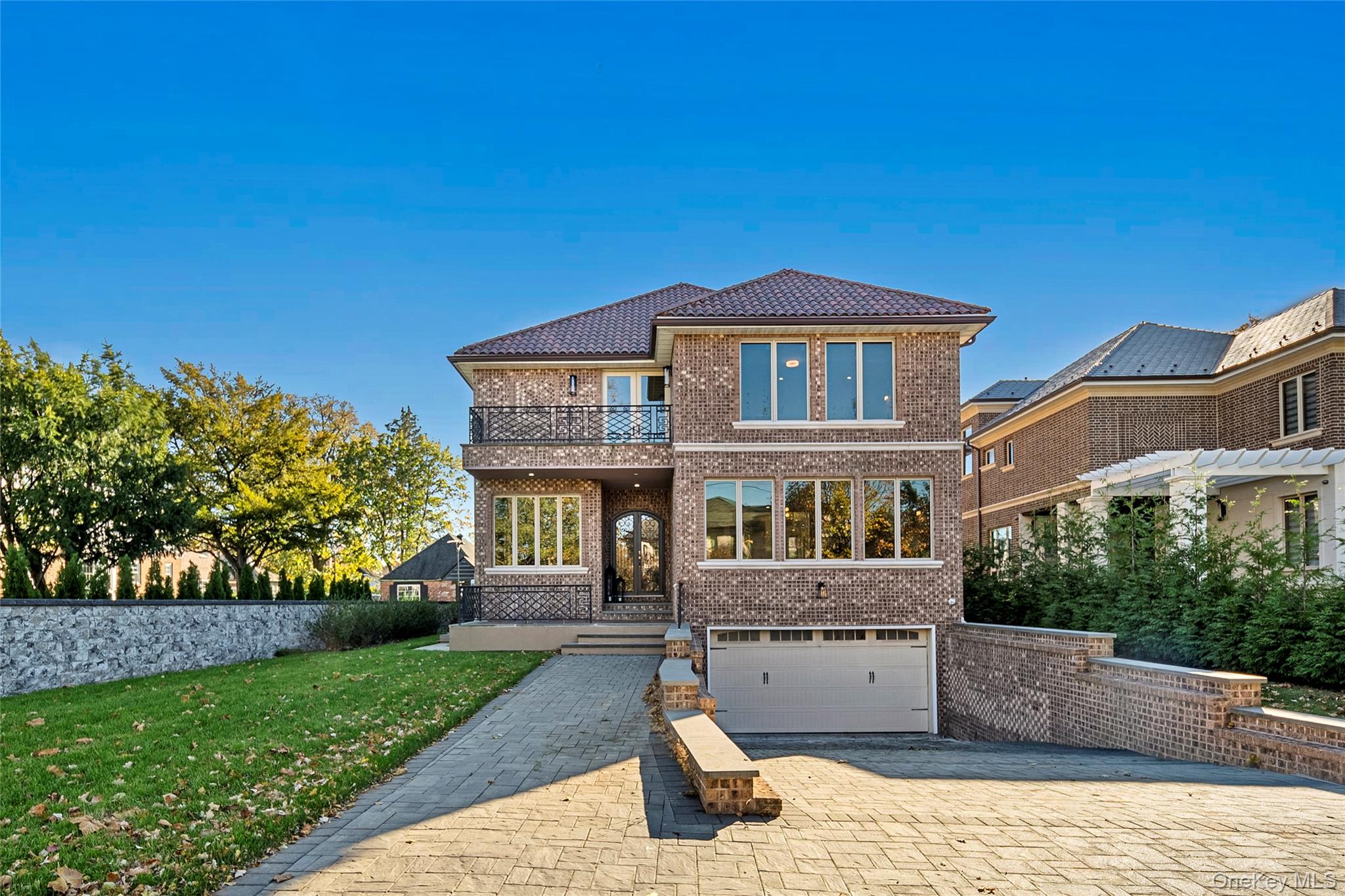 Custom full brick Colonial built in 2020 on a rare 11,086 SF lot. Approx. 7,723 SF interior space, 5 bedrooms, 4.5 baths. Main level offers grand living room, formal dining, open-concept kitchen w/ access to deck, plus bedroom/office. Second floor features 2 master suites, spacious bedrooms, front/back balconies with partial Whitestone Bridge & city views. Finished basement w/ legal CO includes master bedroom, office/utility room, laundry, security system & private entrance — ideal for extended living. Indoor 2-car garage. Room for sport ,Prime & private residential location, minutes to major highways, shopping & dining.