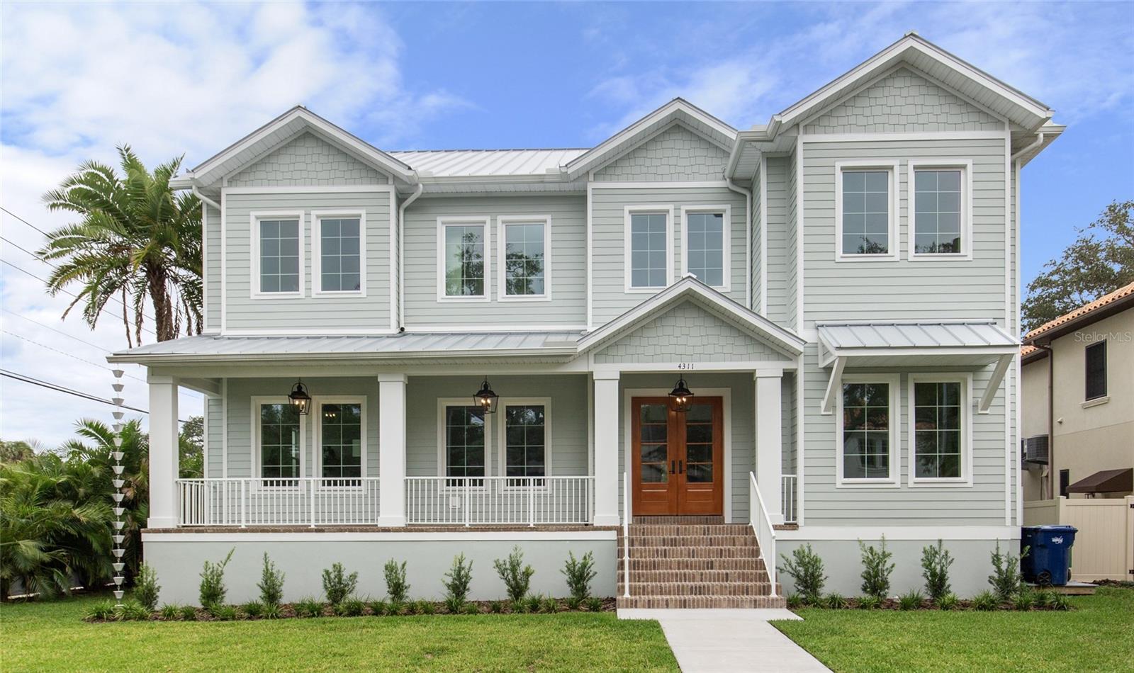 NEWLY COMPLETE AND MOVE-IN READY! This one-of-a-kind two-story block construction residence by Southerlyn Homes delivers nearly 5,000 sq. ft. of refined living space with 5 bedrooms and 6 baths, set on an oversized 75x120 corner lot in the heart of prestigious Virginia Park. Built well beyond code with an elevated foundation, standing seam metal roof, Hardie siding, impact-rated windows/doors, and a sealed building envelope with mechanical ventilation, the home is designed for timeless curb appeal and lasting durability. Southerlyn Homes never builds the same house twice, and this custom plan showcases bespoke architectural details and thoughtful spaces throughout—making it unlike any other new construction home on the market. Representing one of the best new construction values in South Tampa, this residence combines architectural distinction, advanced construction, and thoughtful design in a way rarely found at this price point. Mature landscaping, a new privacy fence along Manhattan, and an extended rear fence create a secluded setting while expanding the usable backyard. Inside, 10-ft ceilings, 8-ft solid-core doors, wide-plank white oak flooring, and abundant natural light set an elegant tone. The chef’s kitchen features an oversized island, quartz counters, premium KitchenAid appliances including a 42” built-in refrigerator and 36” gas range, a walk-in pantry, and a butler’s pantry with wet bar and wine fridge. The open living area flows seamlessly outdoors to a covered lanai with summer kitchen, overlooking a fully automated saltwater pool and spa with heat/cool, sun shelf, LED lighting, and a newly completed shell-stone pool deck, complemented by a dedicated pool bath. The first-floor primary suite includes a spa-inspired bath with soaking tub, dual rain-head walk-through shower, dual vanities with makeup counter, and dual custom closets with built-ins and stacked washer/dryer hookup. Upstairs are four additional bedrooms—including two guest suites with private baths and a Jack-and-Jill—plus a large media/bonus room with full wet bar and beverage/wine cooler, and an oversized laundry room with extensive cabinetry. Additional upgrades include dual HVAC systems with UV purification, 400-amp electrical service, tankless gas water heaters, LED ambient/under-cabinet lighting, a 2-car garage with soaring ceiling and Wi-Fi opener, and a fully integrated smart-home system with security panels, surround-sound pre-wire, multiple speaker zones, Cat6 wiring, fiber internet, and hardwired Eero Wi-Fi. All closets are finished with custom built-ins, and the exterior includes zoned irrigation and underground electric for a clean streetscape. Walkable to shops and dining with effortless access to downtown, TGH, Westshore, International Plaza, and TPA, and zoned for Mabry, Coleman, and Plant schools, this Southerlyn Homes signature design delivers unmatched craftsmanship and a rare opportunity to own luxury re-imagined, never repeated—at a price point that makes it one of South Tampa’s best values today.