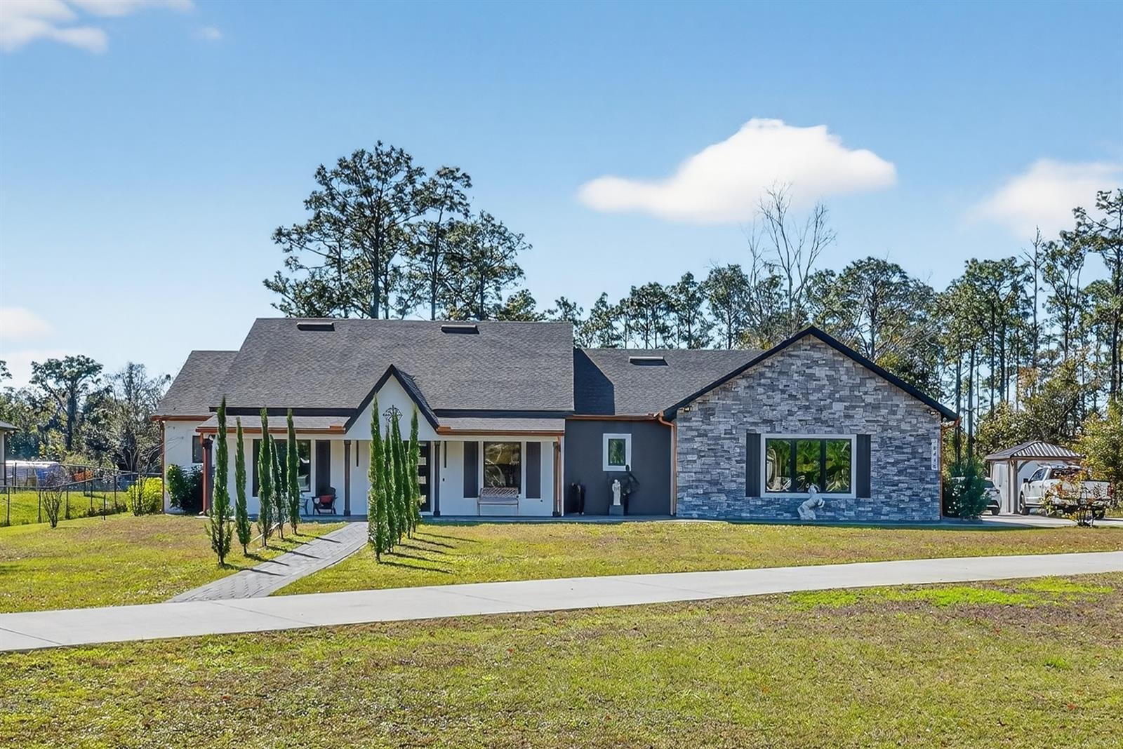 Under contract-accepting backup offers. Welcome to 19438 Sheldon St, a refined modern residence located in the highly desirable Wedgefield community, offering the rare balance of country-style living with city convenience. This prime location provides easy access to the Lake Nona area, major roadways, and a comfortable drive to Florida’s beautiful beaches. NO HOA and 1.7 acres provide the space, privacy, and freedom, all while remaining close to Orlando amenities and the coast. It offers the possibility of building another property, an extra storage unit and more.Inside, the home features an open-concept design with high ceilings and abundant natural light. Expansive windows and sleek glass accents create a seamless flow between the living, dining, and kitchen spaces, delivering an elegant yet inviting atmosphere.The chef-inspired kitchen showcases quartz countertops, a generous island, white wood cabinetry, stainless-steel appliances, and an oversized walk-in pantry, ideal for both elevated entertaining and everyday living. Clean architectural lines and modern-industrial details add timeless sophistication throughout.The primary suite offers a private retreat with a spa-style bathroom featuring a jacuzzi tub. An oversized laundry room and oversized garage enhance functionality and storage, while a fully paid water filtration and security system provides added value and peace of mind.A covered patio extends the living space outdoors, perfect for relaxing or entertaining while enjoying the tranquillity of the area. A distinctive opportunity combining modern luxury, thoughtful upgrades, and an exceptional location. Schedule your private showing today!